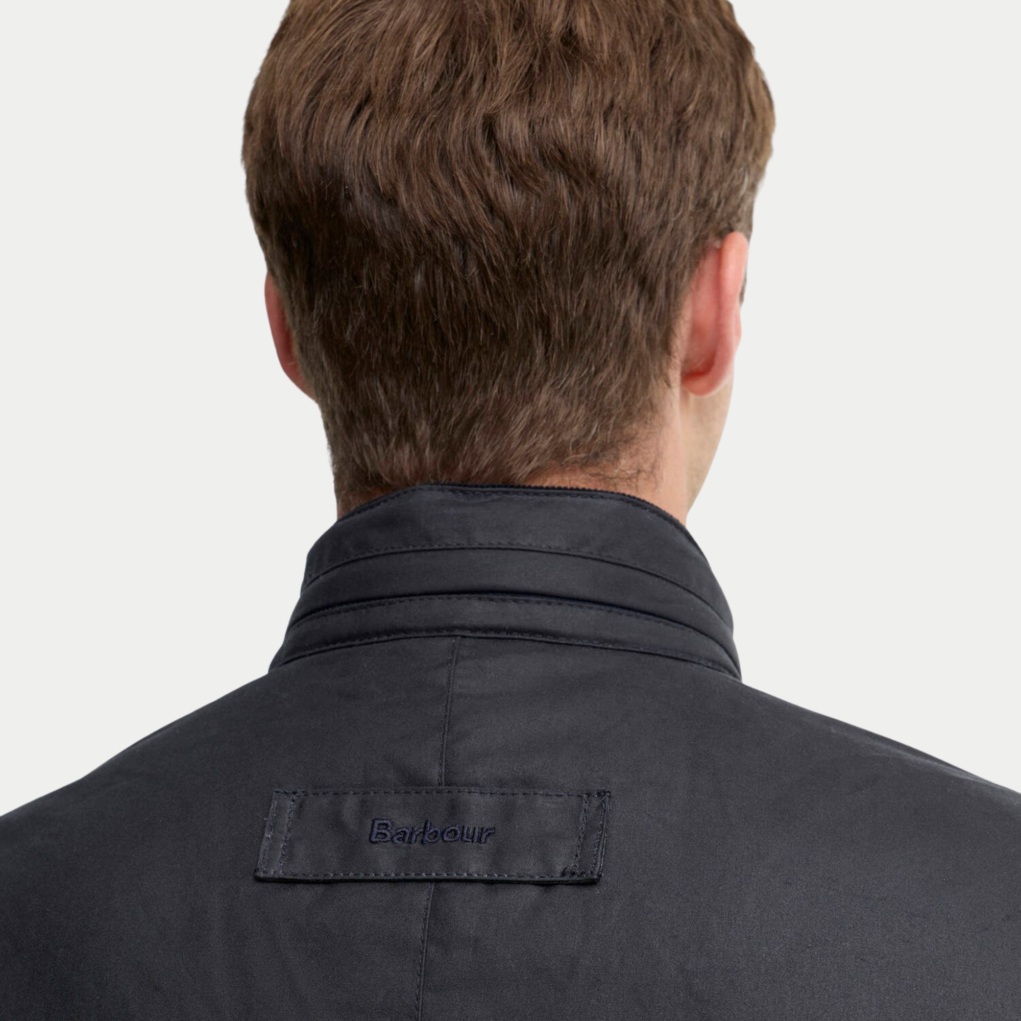 Col montant de la veste Corbridge marine vu de dos, surpiqûres et patte Barbour brodée ton sur ton