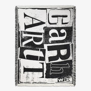Couverture tissée noir et écru à grandes lettres d'imprimerie, bordée de franges sur ses quatre côtés