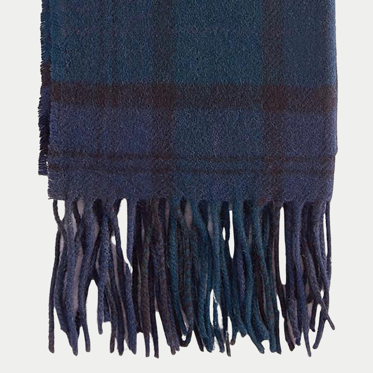 Détail des franges de l'écharpe Barbour tartan Black Watch, carreaux bleu marine et vert sapin à lignes sombres