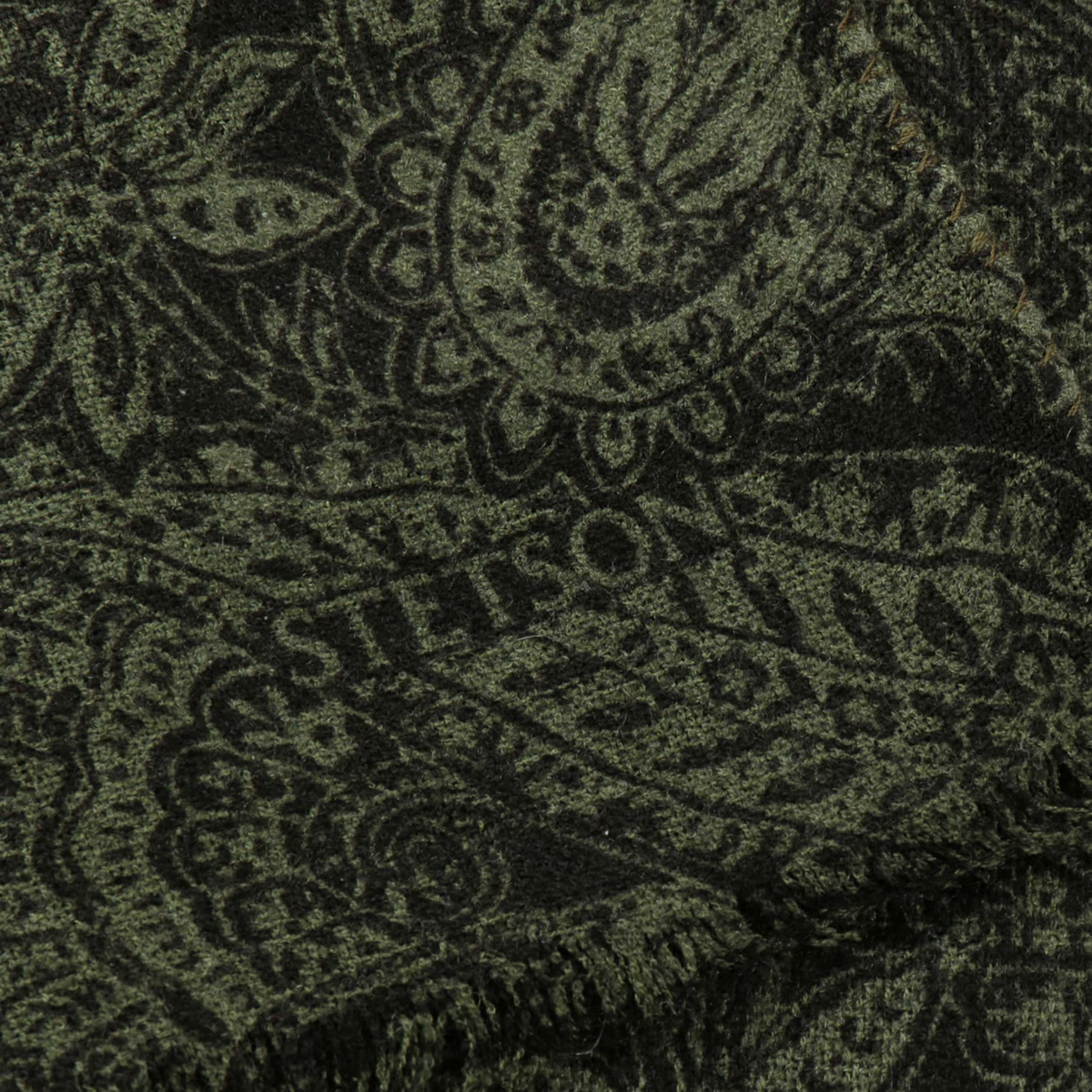 Détail de l'écharpe paisley bicolore Stetson : logo Stetson tissé dans le paisley olive et noir, bord frangé