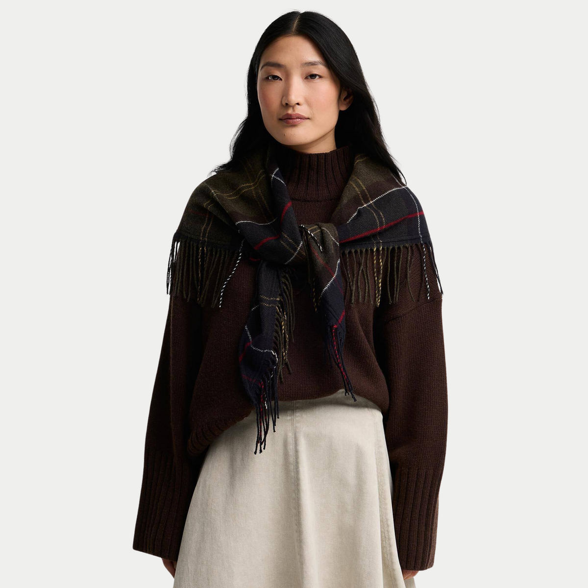 Écharpe triangle Kirklees tartan olive portée nouée sur les épaules, pointe et franges sur un pull marron