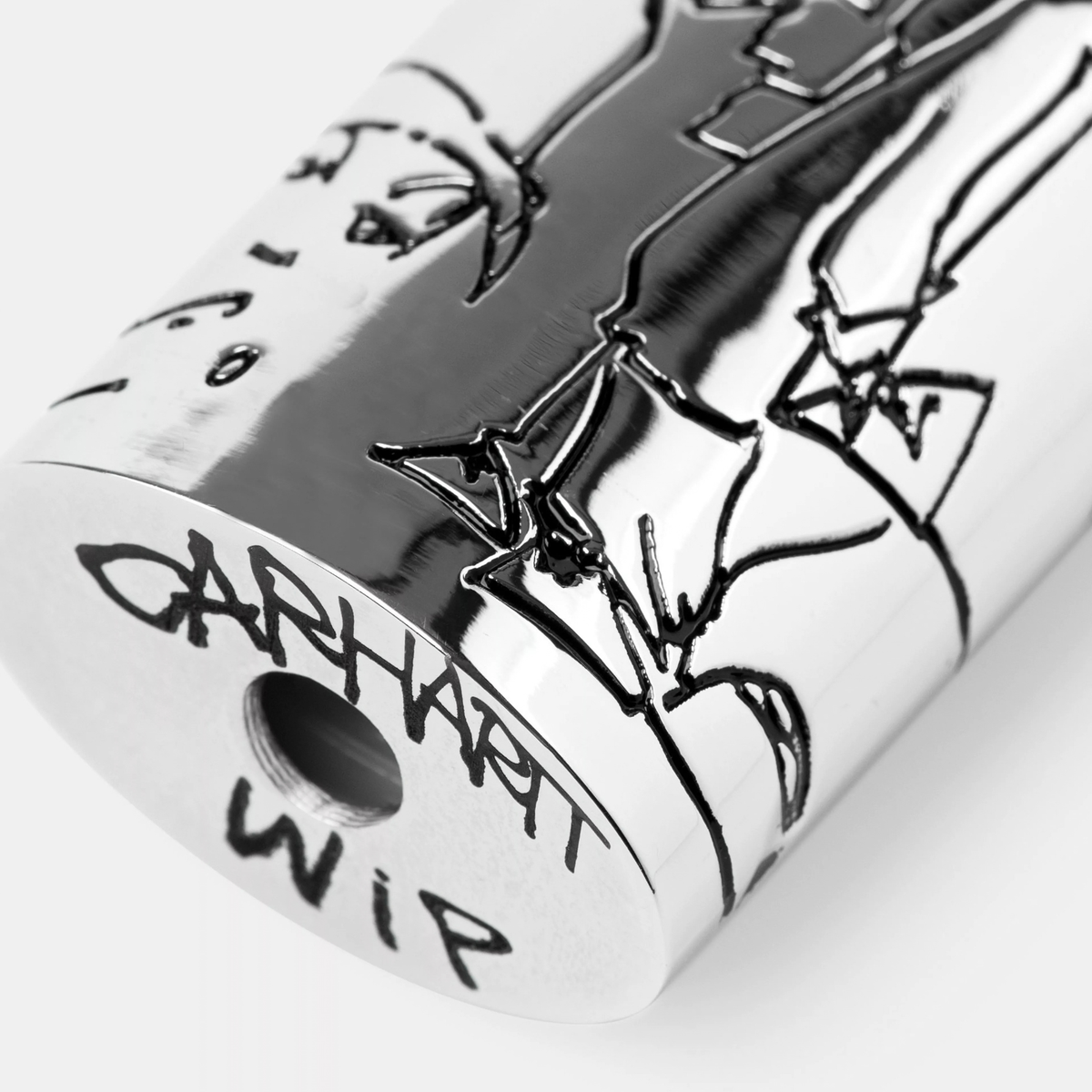Gros plan sur la base de l’étui à briquet Blinkerfluid Carhartt WIP : signature gravée et ouverture ronde du boîtier