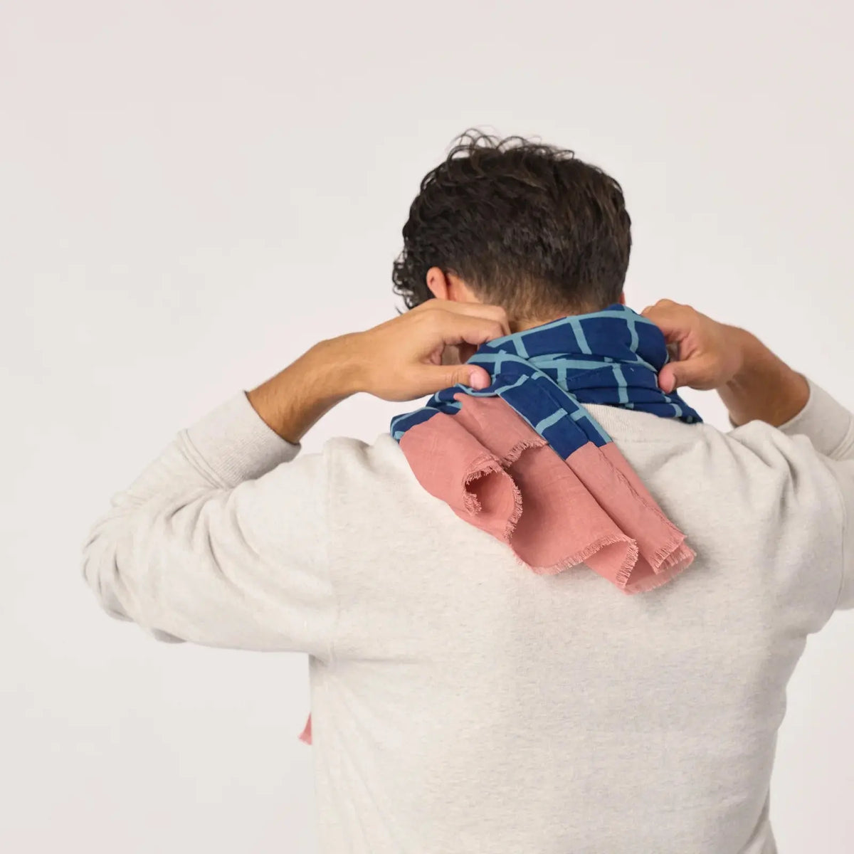 Foulard à carreaux ajusté dans la nuque et vu de dos, pans rose terracotta terminés par des franges
