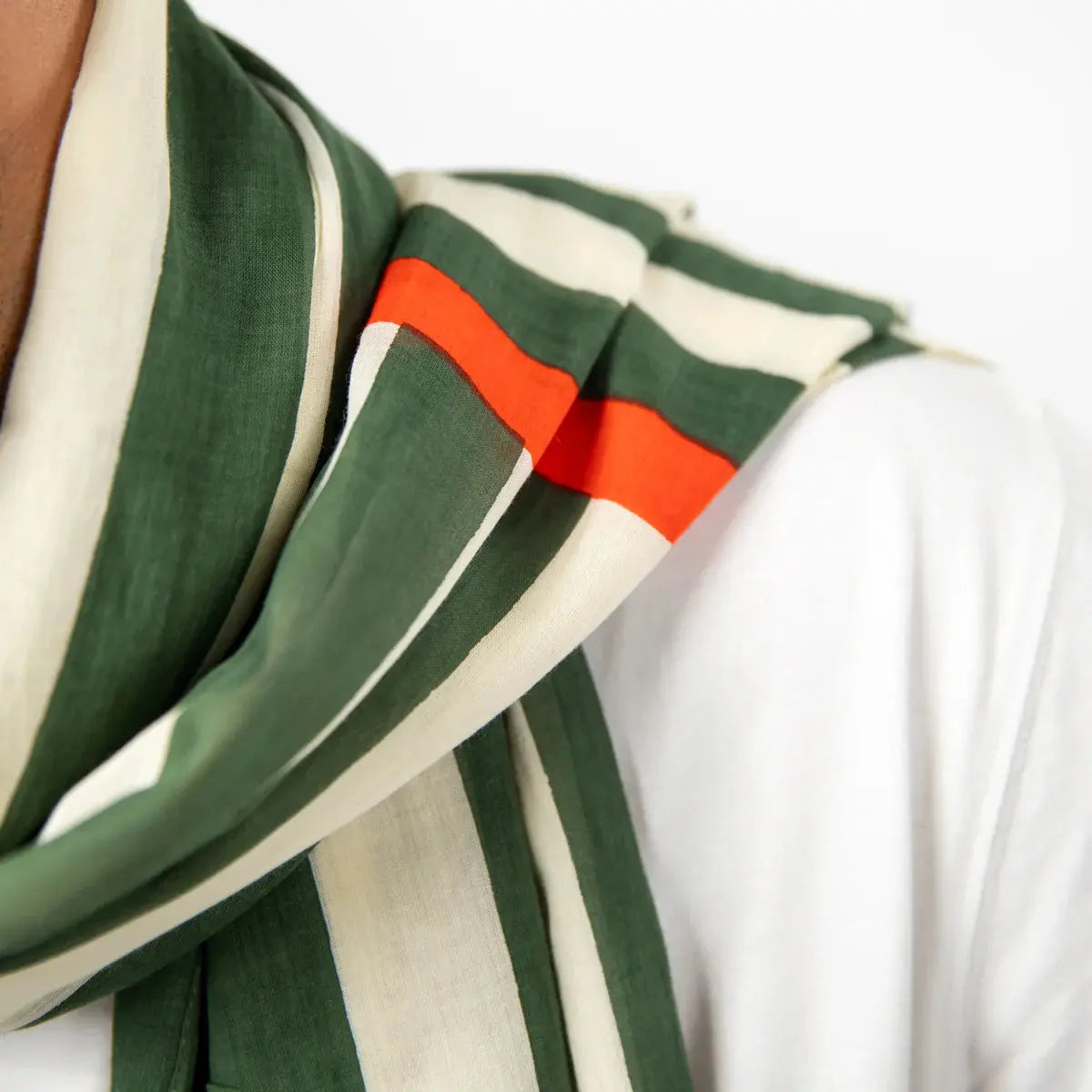 Détail des rayures vert kaki et écru croisées d'une bande orange sur un voile de coton très léger