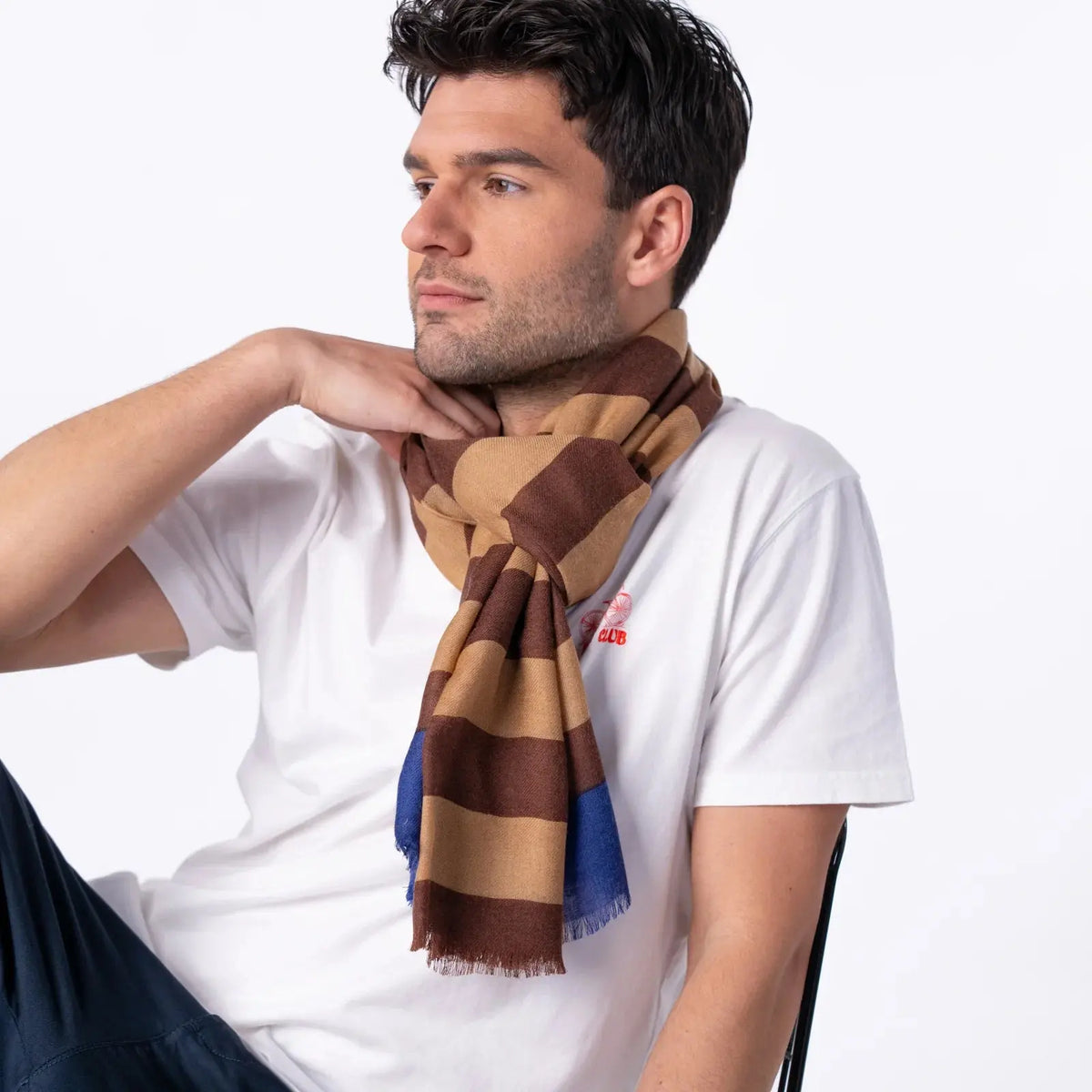 Foulard en laine à rayures camel et chocolat porté noué, franges effilochées en bout des deux pans