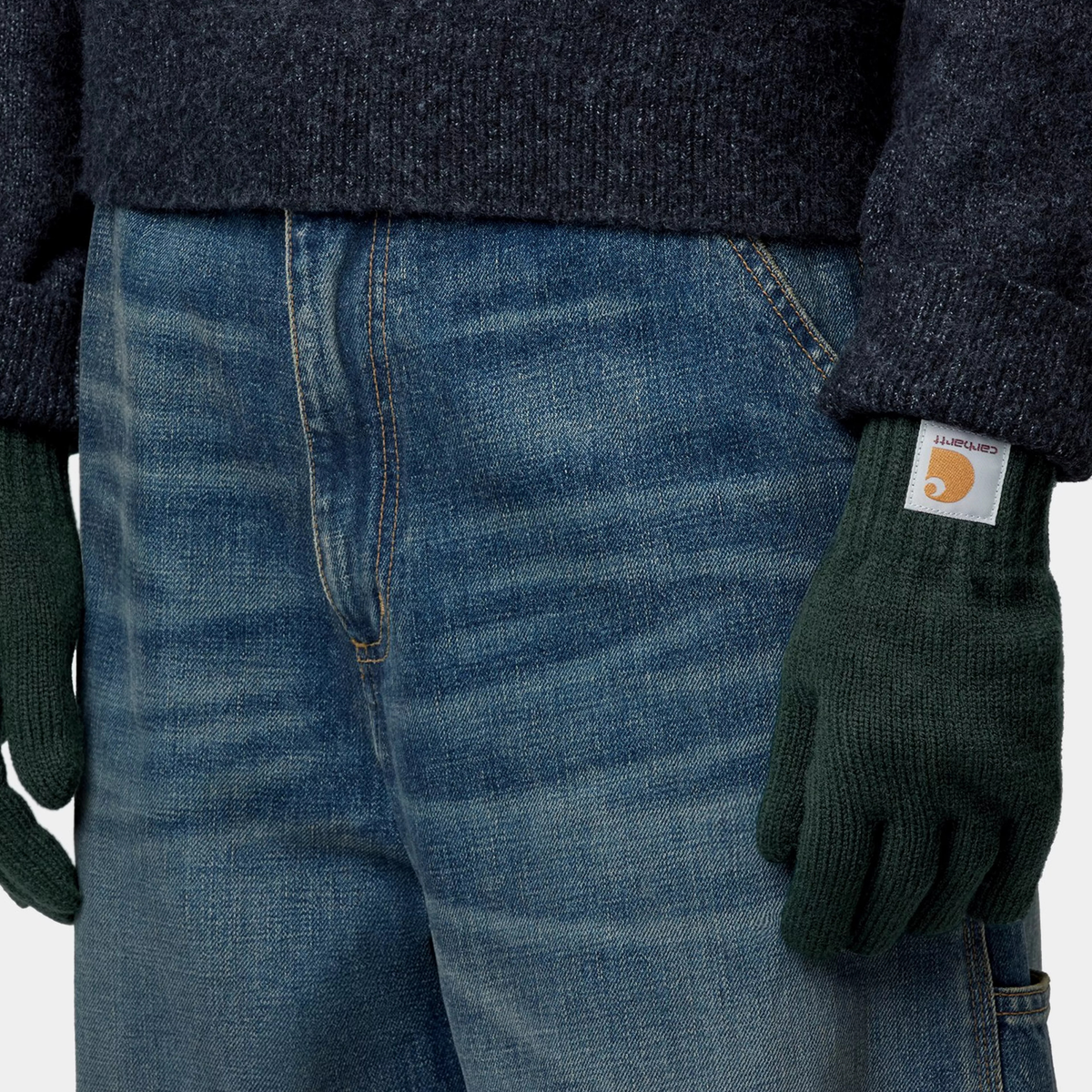 Gants Watch Dark Scarab Carhartt WIP - portés avec un jean et un pull en maille, poignet côtelé