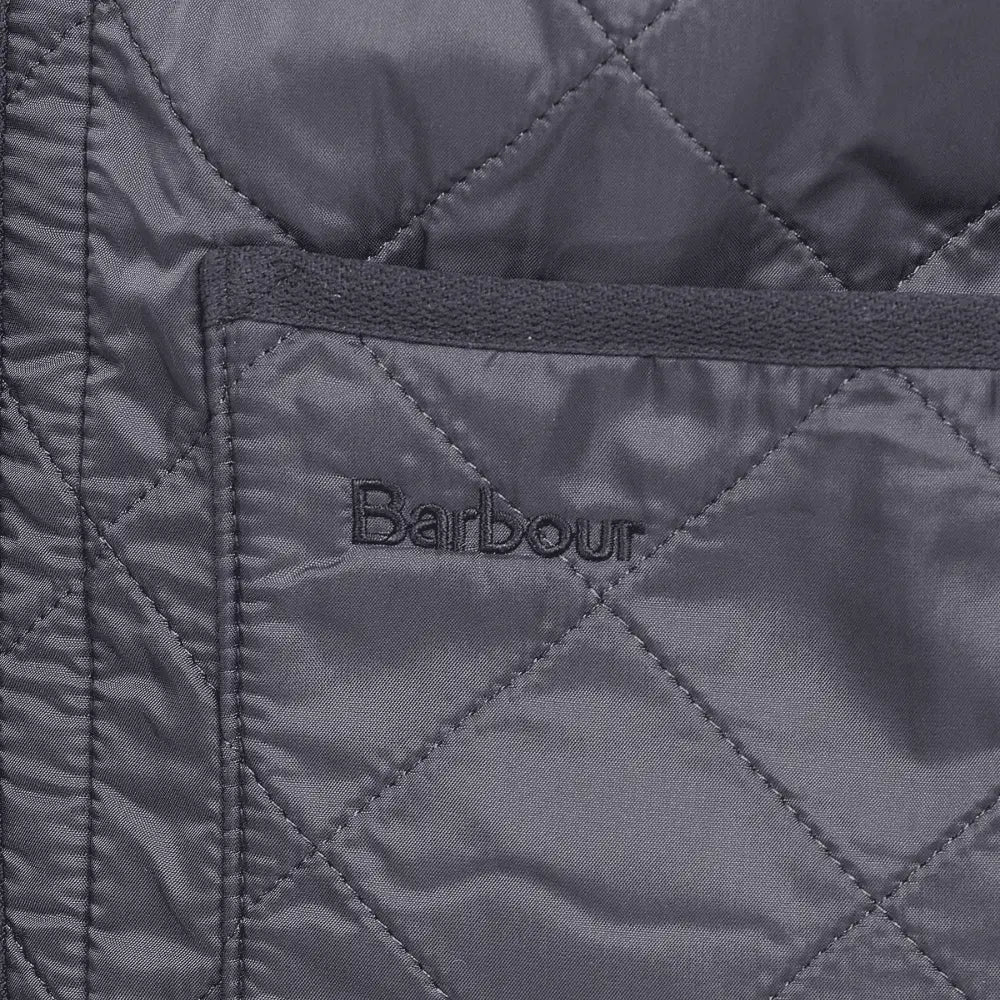 Macro du matelassage losanges, du bord côtelé et du logo brodé sur la poche