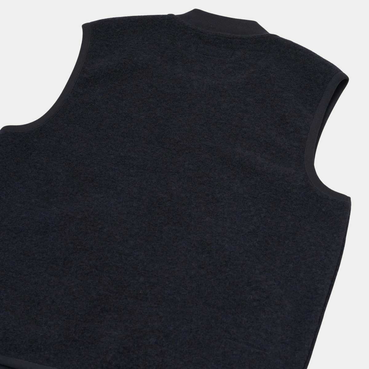 Dos du gilet zippé Universal Works bleu marine à plat, emmanchures bordées de jersey