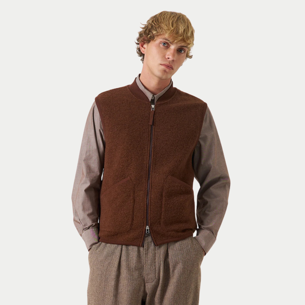 Gilet zippé Universal Works marron porté sur une chemise taupe et un pantalon à chevrons, vue de face