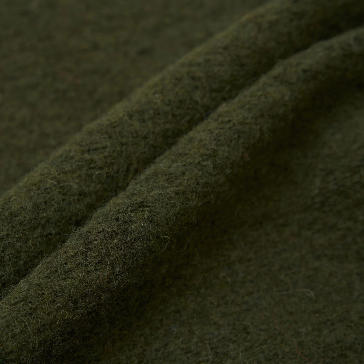 Gros plan sur les plis du Wool Fleece vert olive chiné du gilet zippé Universal Works
