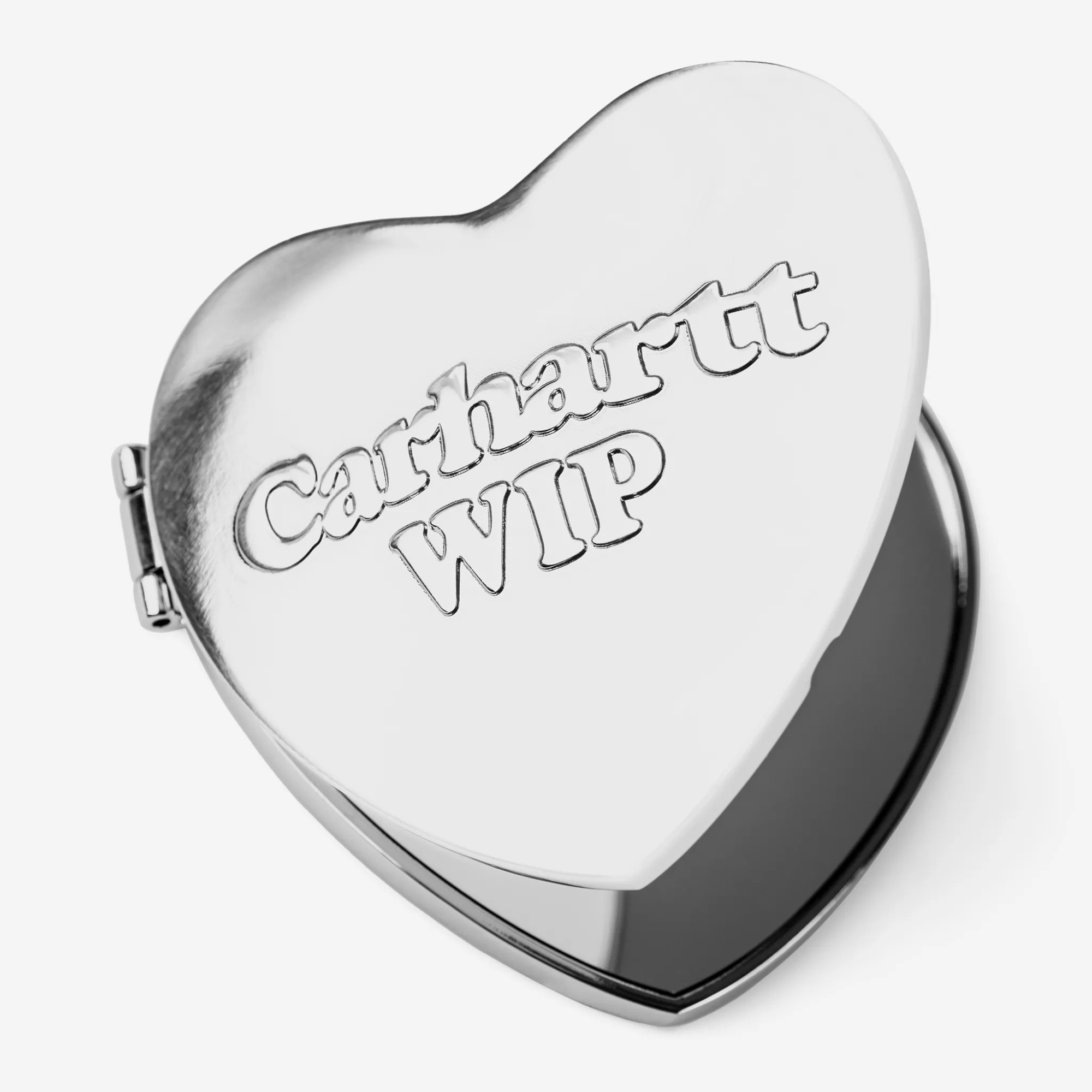 Miroir de poche Heart Carhartt WIP en zinc chromé, vu de trois quarts, lettrage embossé et charnière latérale