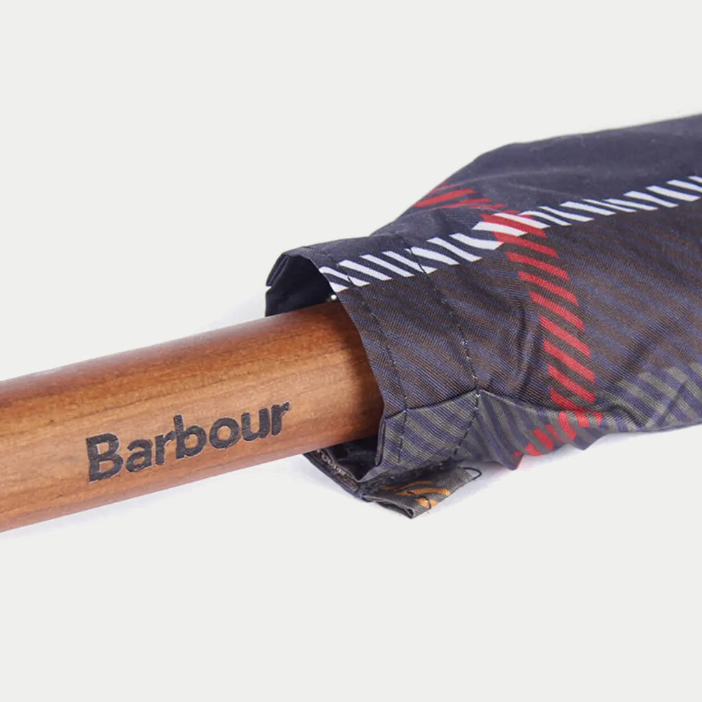 Détail du manche en bois verni du parapluie Walker Barbour, logo gravé, toile tartan olive repliée au-dessus