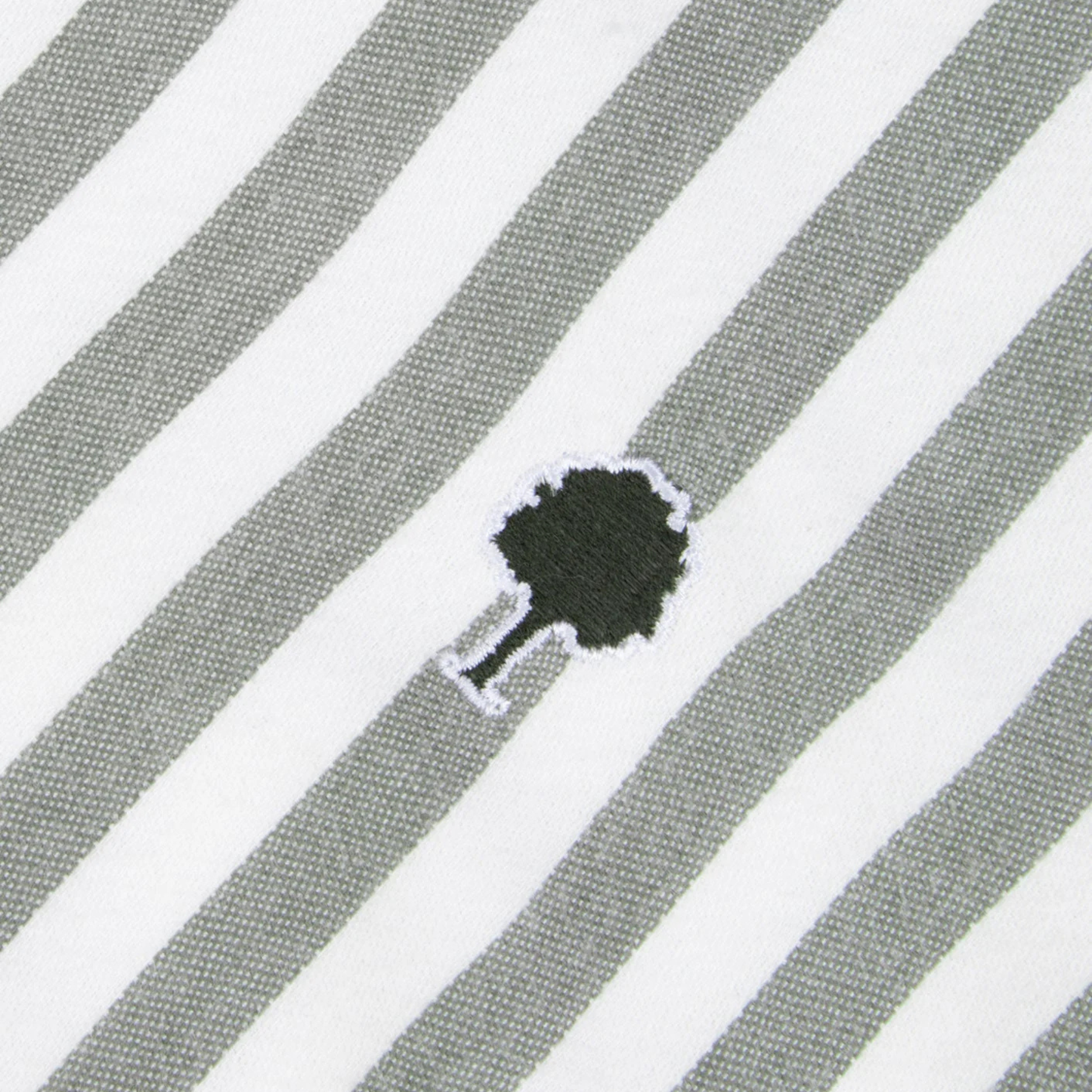 Détail du tissu oxford rayé kaki et écru de la chemise Ivoy et de l'arbre brodé vert foncé