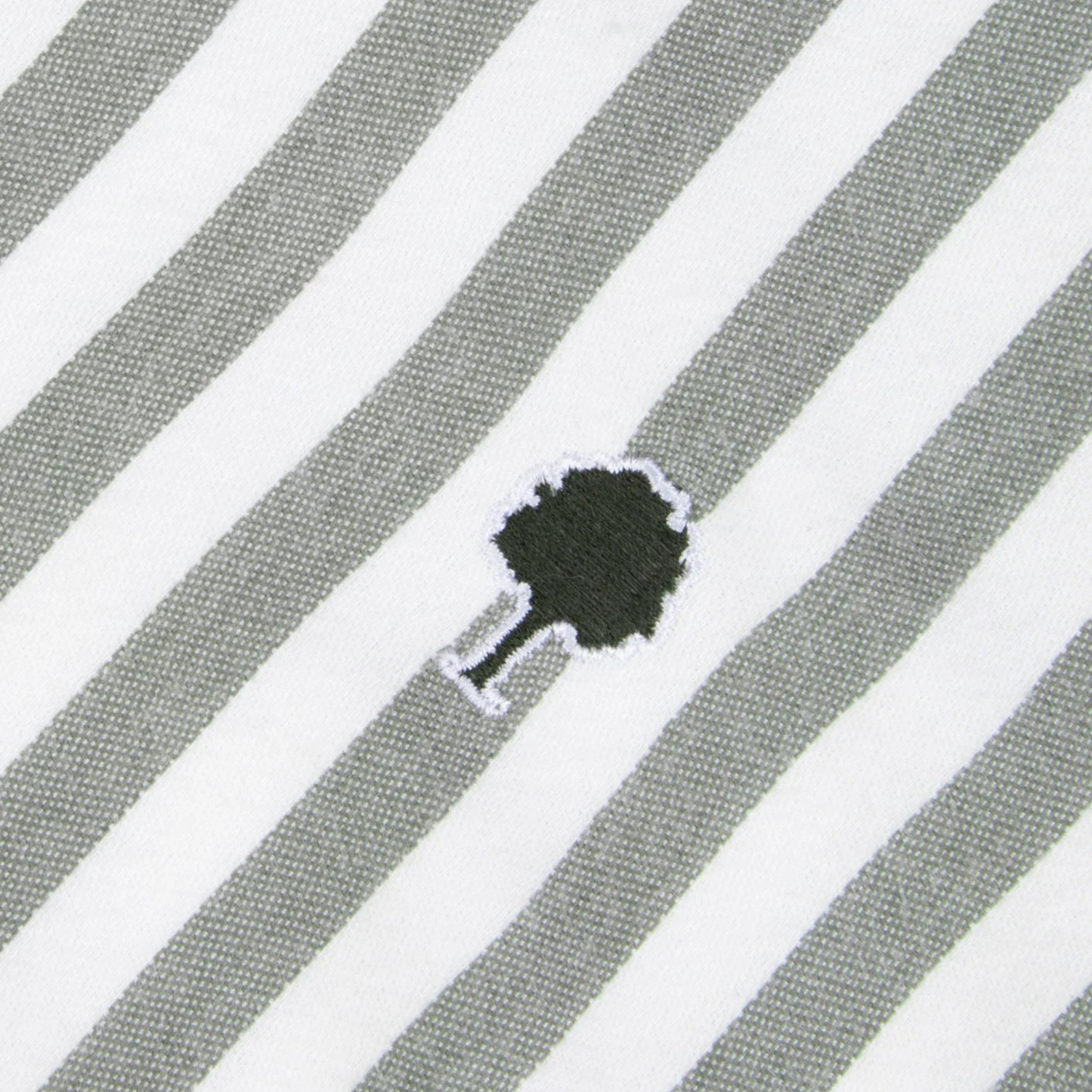 Détail du tissu oxford rayé kaki et écru de la chemise Ivoy et de l'arbre brodé vert foncé