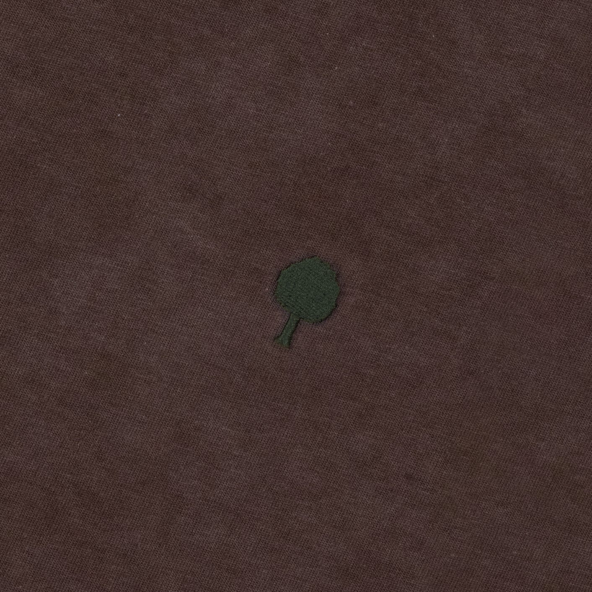 Détail de la broderie arbre FAGUO vert foncé sur le jersey marron délavé du T-shirt Lugny