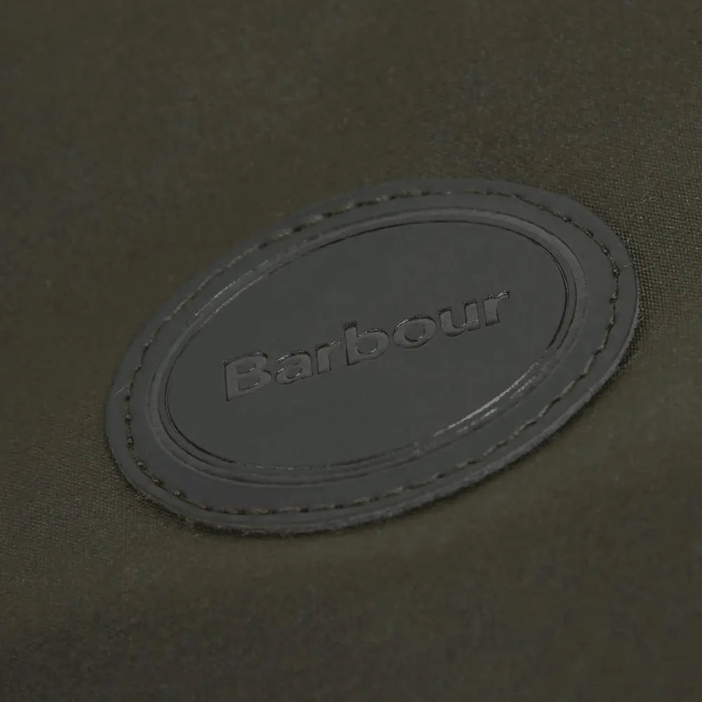 Macro du patch cuir ovale Barbour embossé sur le coton ciré vert olive