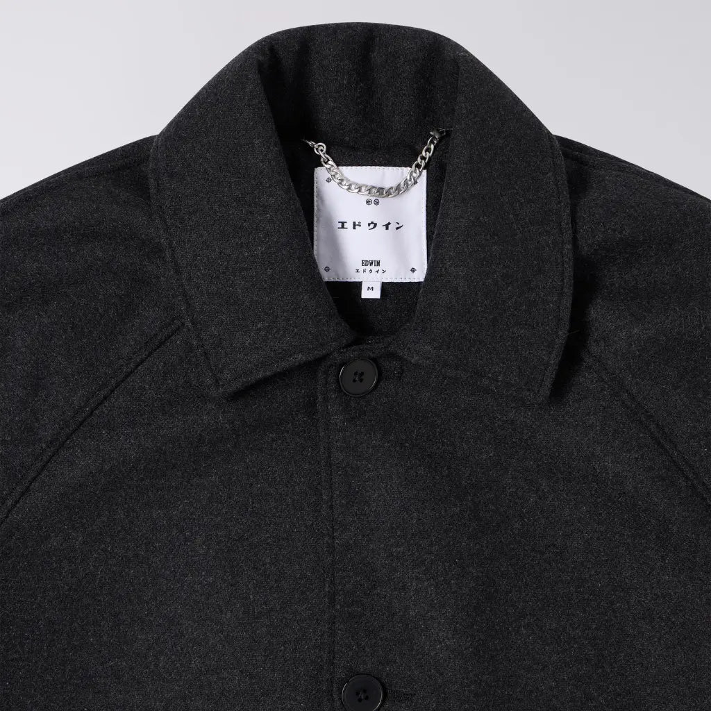 Col du manteau Mac en laine, chaînette d'accroche métallique et étiquette de marque blanche