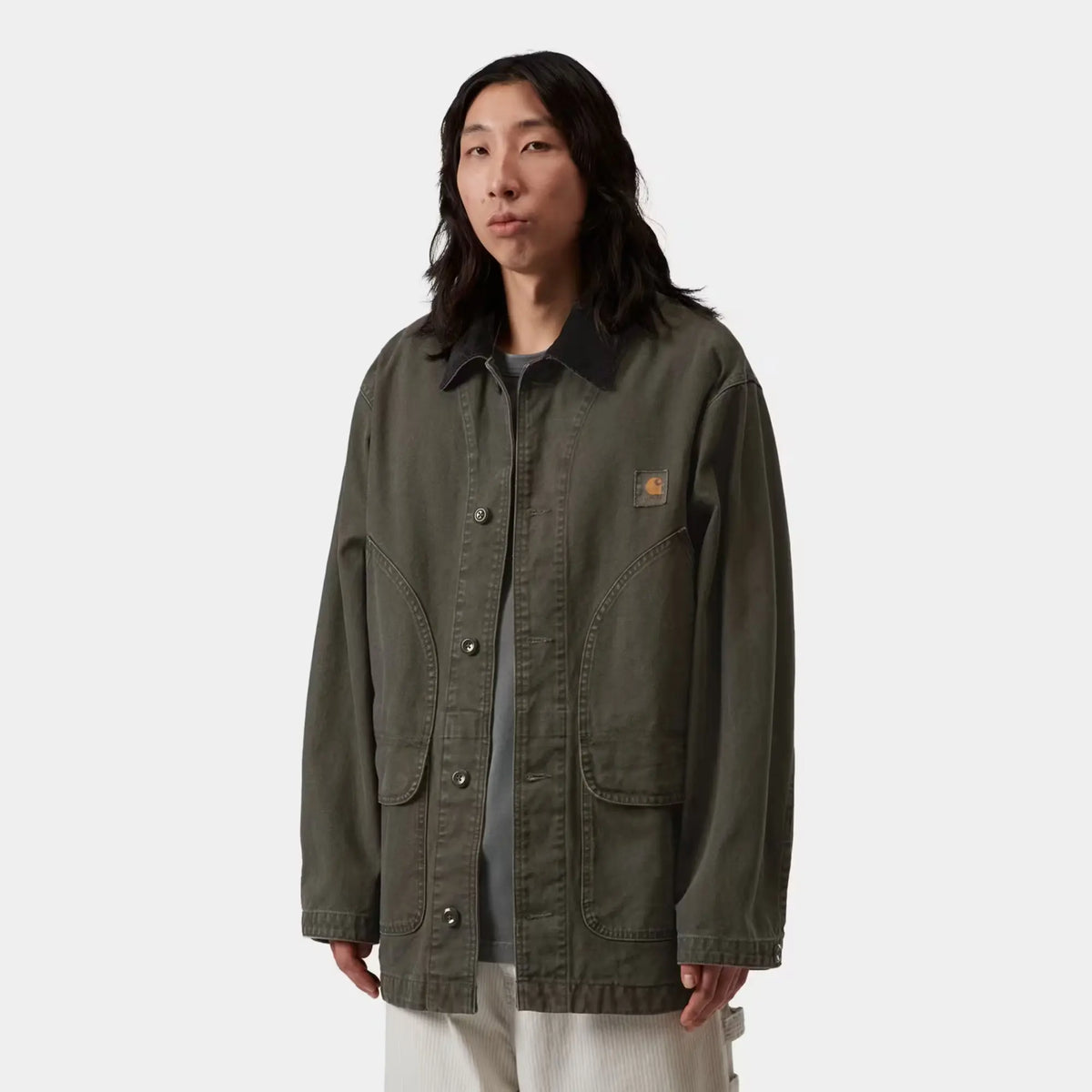 Manteau Prescott Oxide Green porté ouvert : coupe chore ample, col velours côtelé noir, label carré poitrine