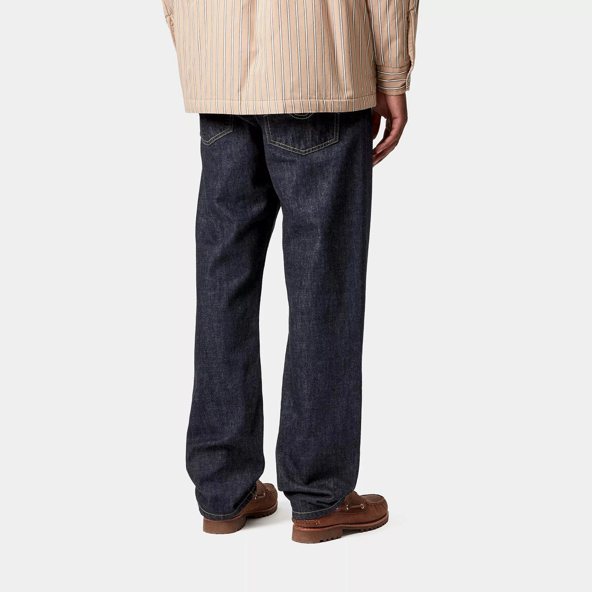 Marlow Pant Blue Rinsed vu de dos porté, jambe droite indigo et poches plaquées à surpiqûre en vague creusée