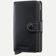 Petit portefeuille en cuir noir fermé, surpiqûres gris clair et bouton pression métal
