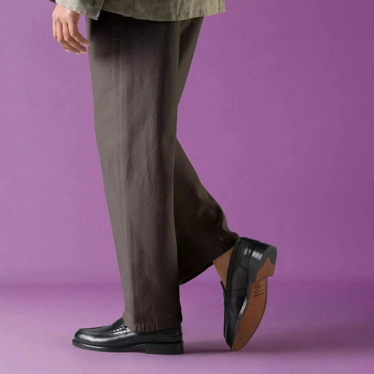 Mocassins Craft James Lo noirs portés avec un pantalon brun, semelle cuir levée