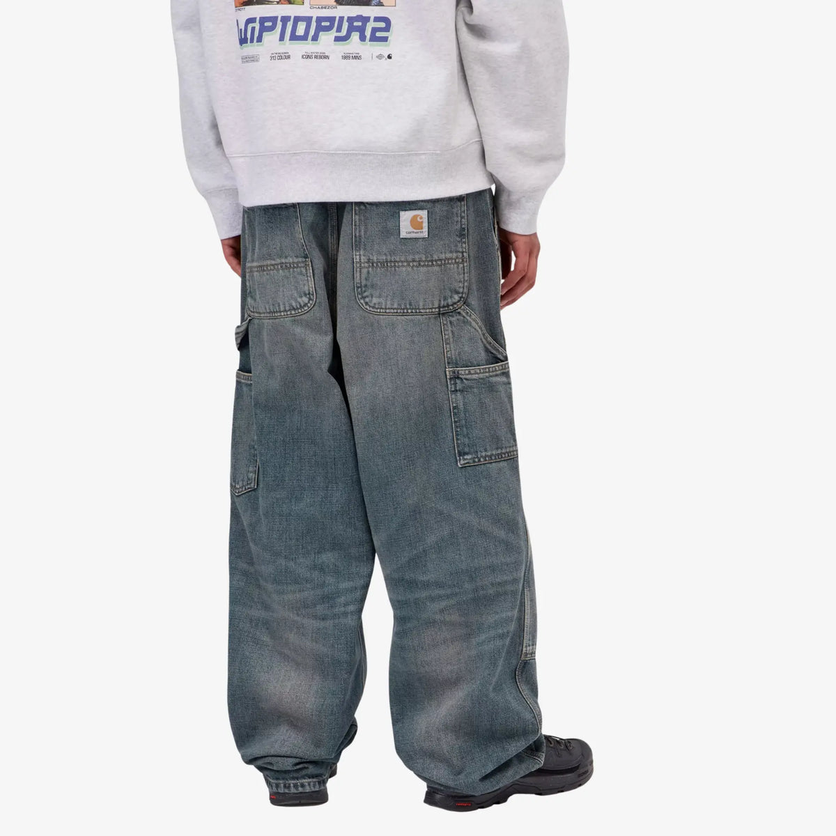 Jean Oakland Carhartt WIP Blue Worn Used Wash porté de dos, coupe ample et étiquette Carhartt à la taille