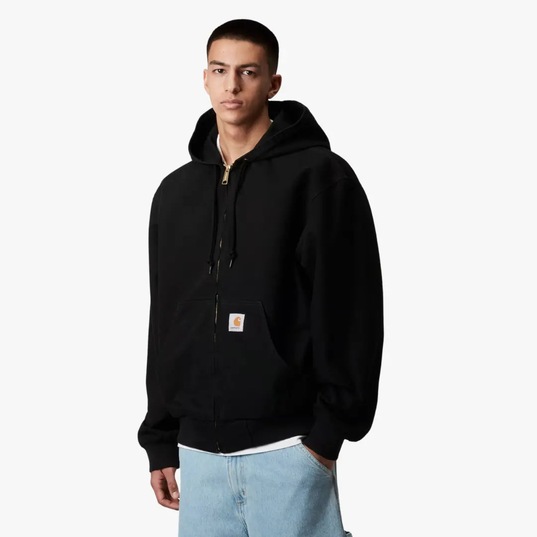 OG Active Jacket noire rinsed portée de trois-quarts, capuche rabattue et étiquette logo sur la poche ventrale