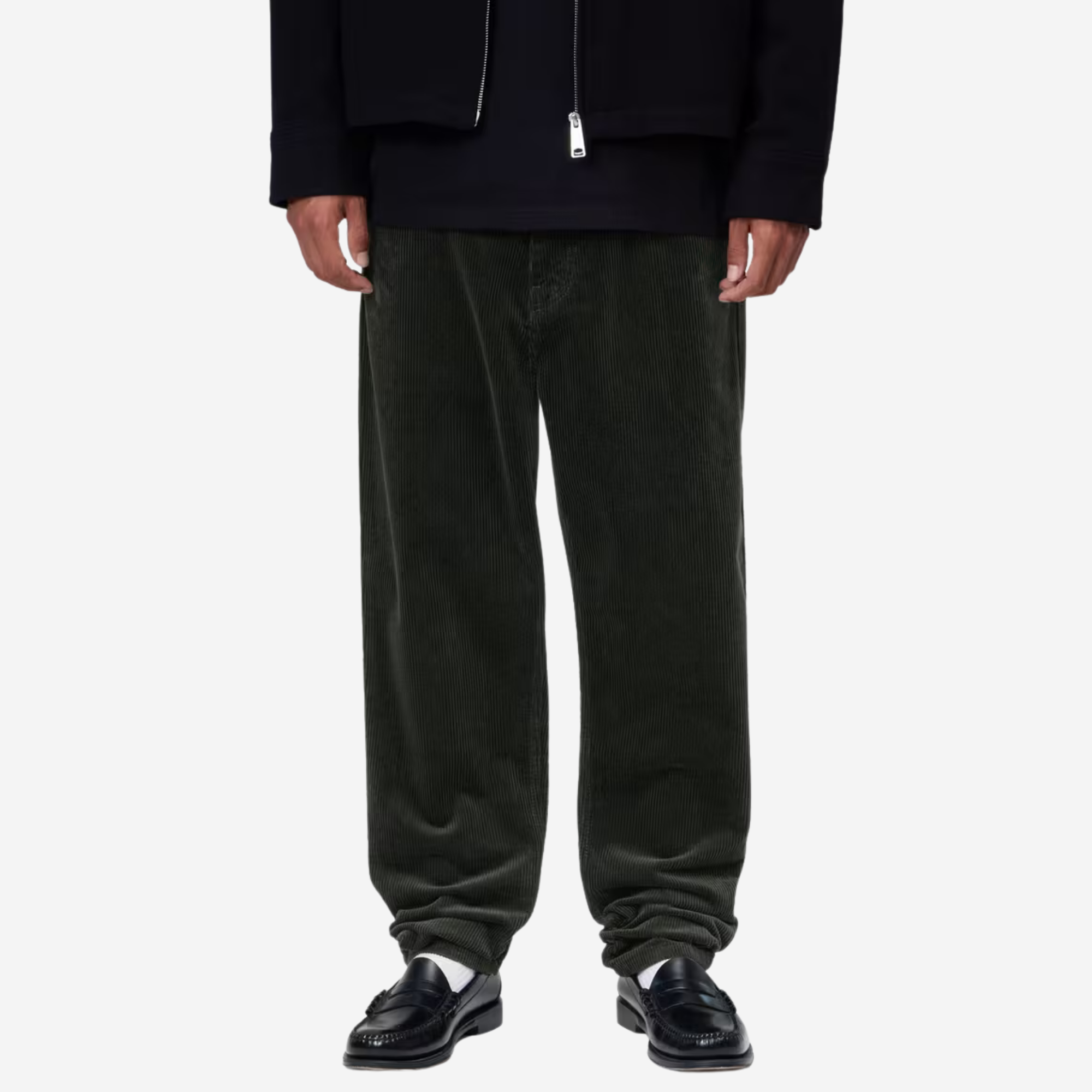Pantalon Newel velours vert foncé Carhartt WIP porté de face avec un sweat marine et des mocassins noirs