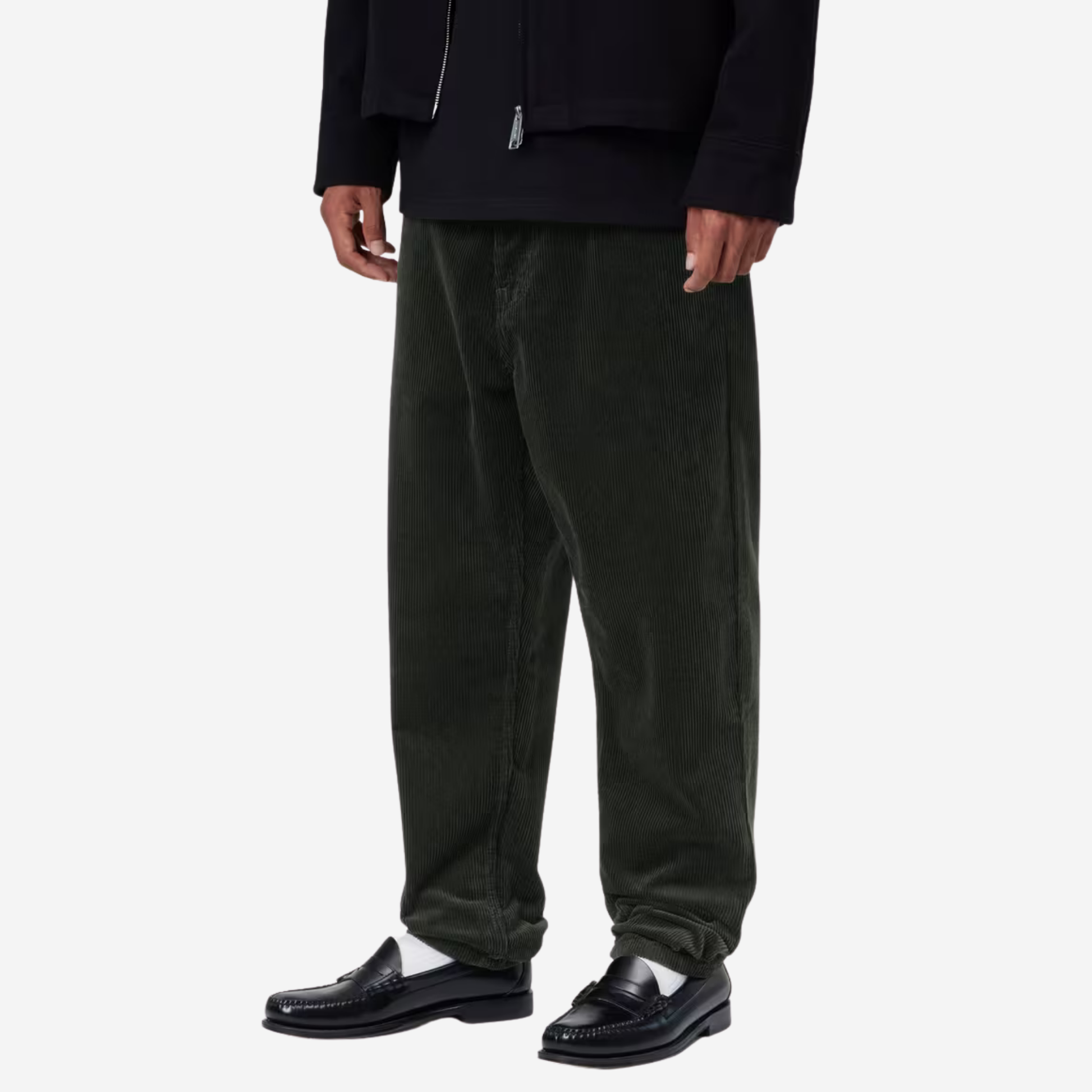 Pantalon Newel velours vert foncé Carhartt WIP porté de trois quarts, grosses côtes du velours en relief