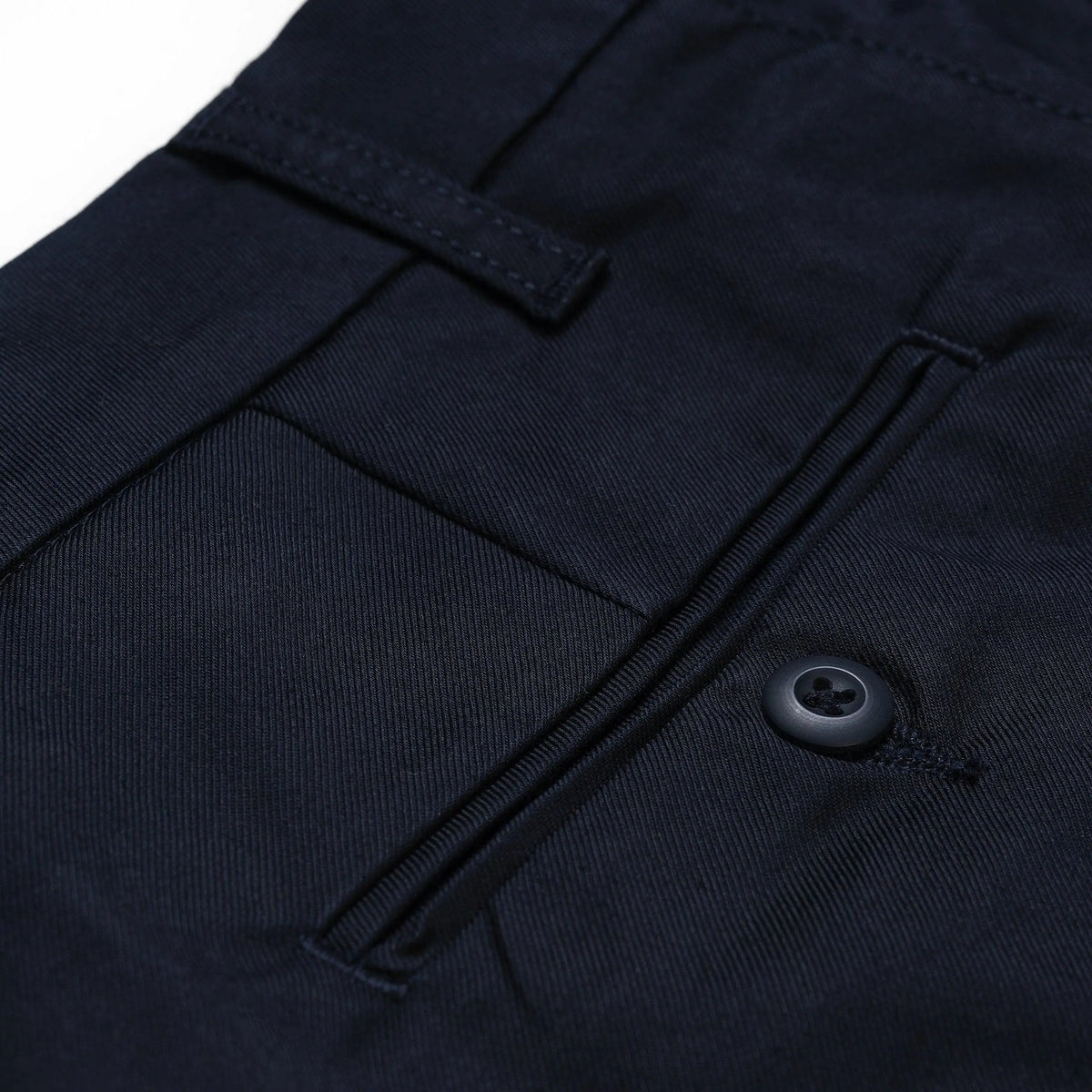 Poche arrière du Sid Pant bleu marine en macro : passepoil, bouton ton sur ton et passant de ceinture