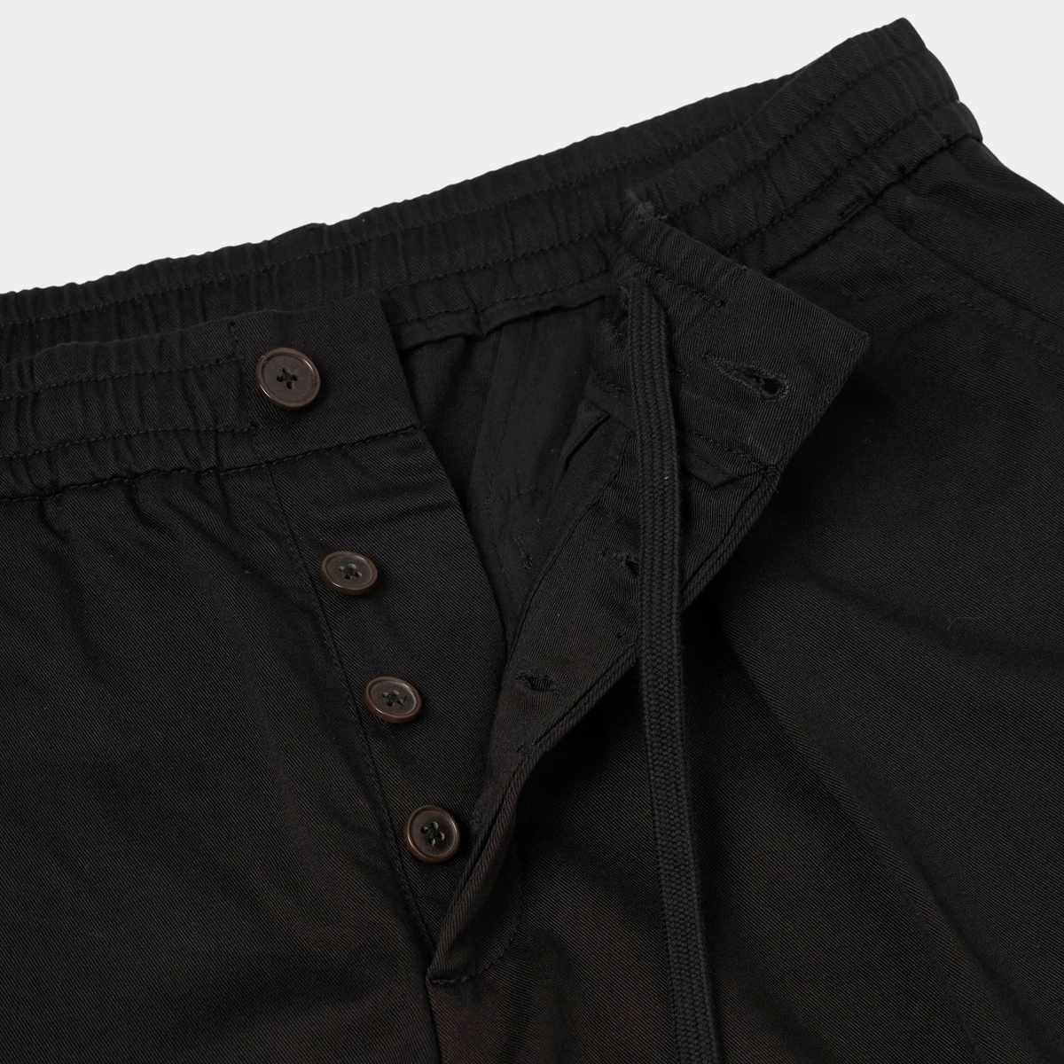 Pleated Track Pant noir Universal Works - détail de la braguette à boutons et du cordon de serrage