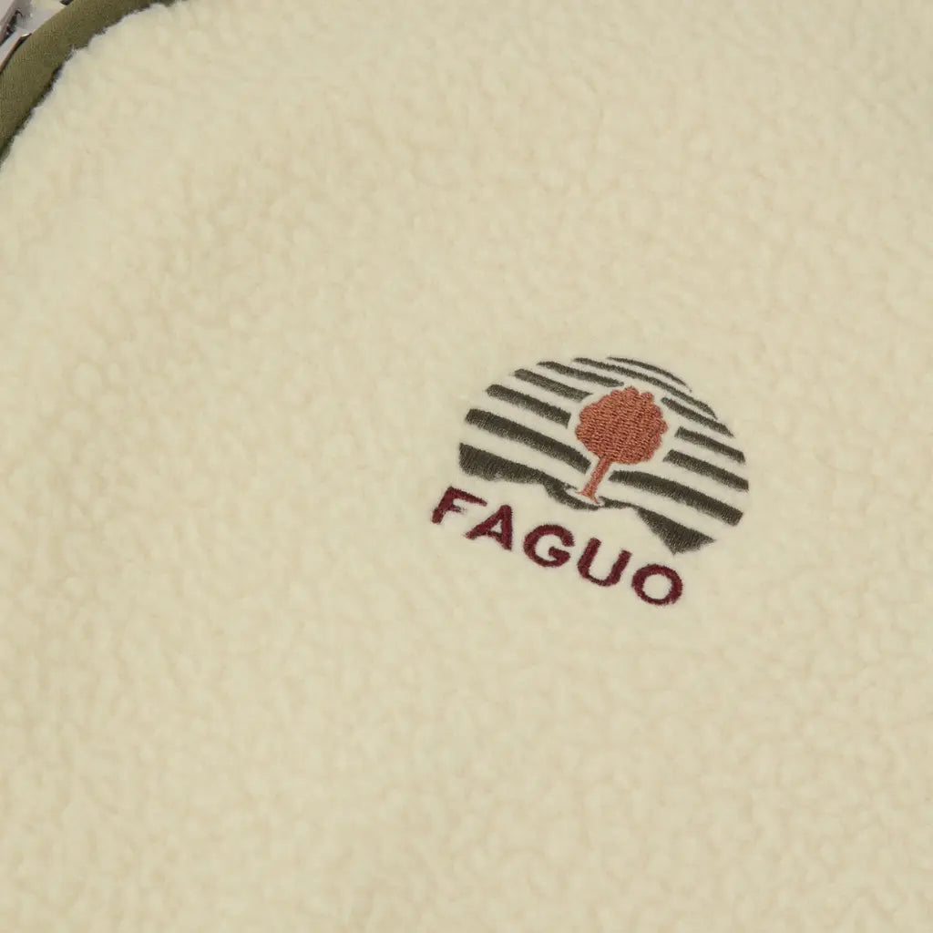 Macro du logo arbre brodé kaki et terracotta sur le sherpa écru de la Teillay