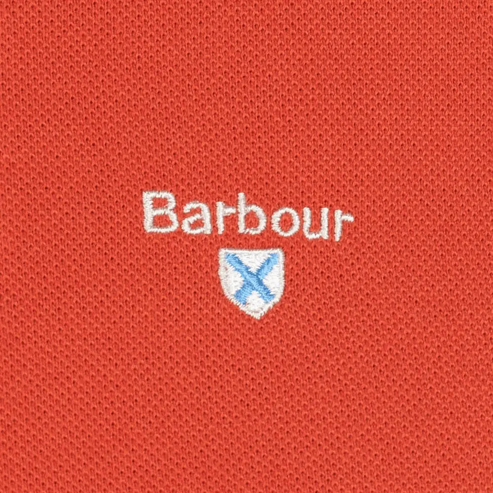 Macro de la broderie Barbour et de son écusson bleu sur le piqué Paprika