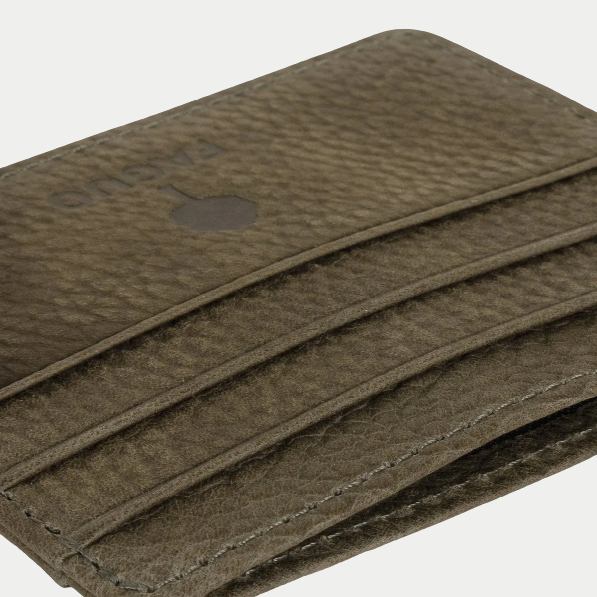 Porte-cartes Faguo vert foncé, gros plan trois-quarts sur le grain du cuir et le logo arbre embossé
