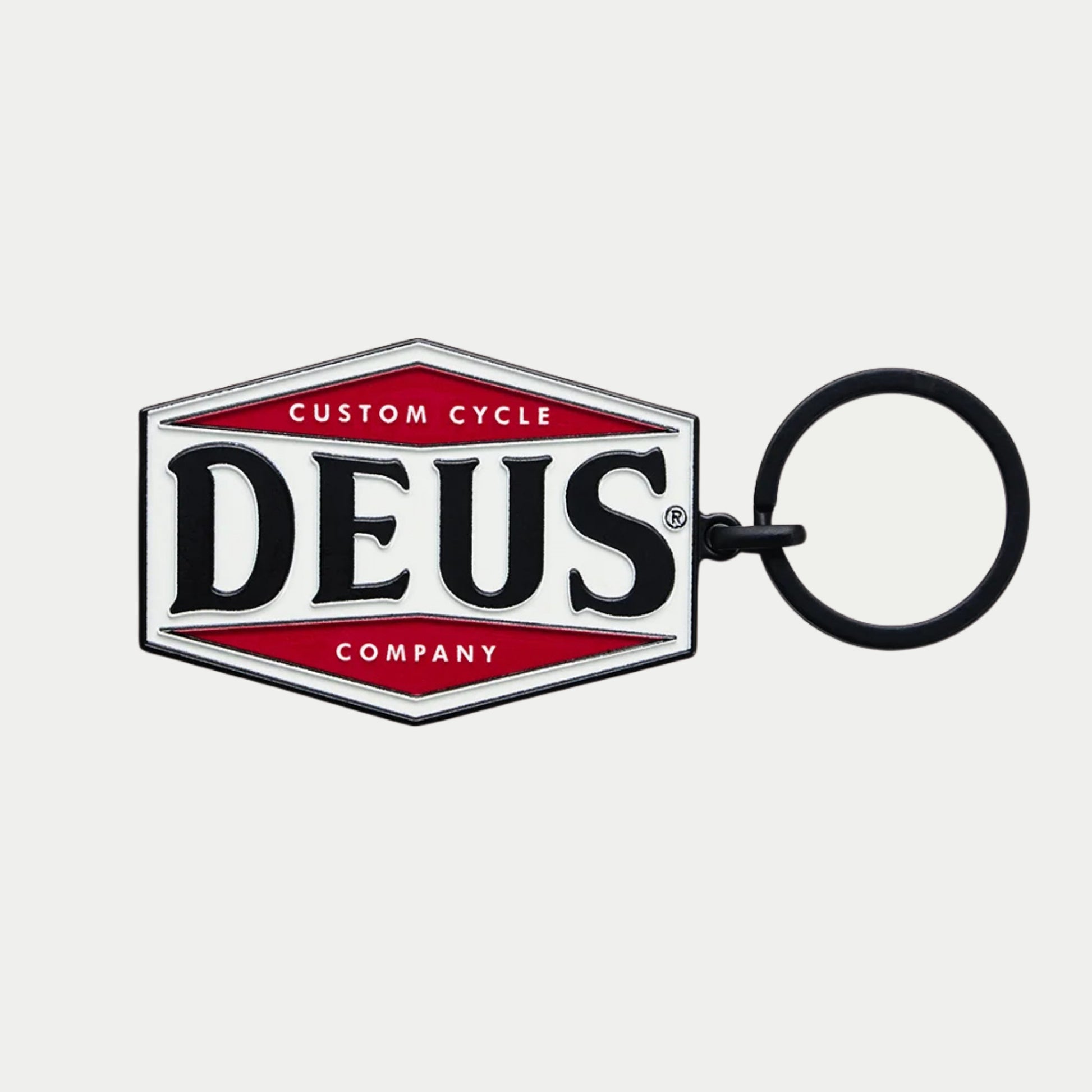 Porte-clés Balsa Deus Ex Machina, écusson hexagonal émaillé blanc à deux losanges rouges, DEUS noir, anneau noir mat
