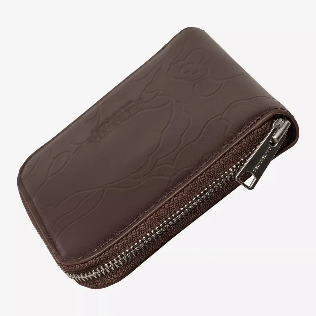 Portefeuille brun chocolat fermé vu de trois quarts, zip argenté sur ruban brun faisant le tour du cuir
