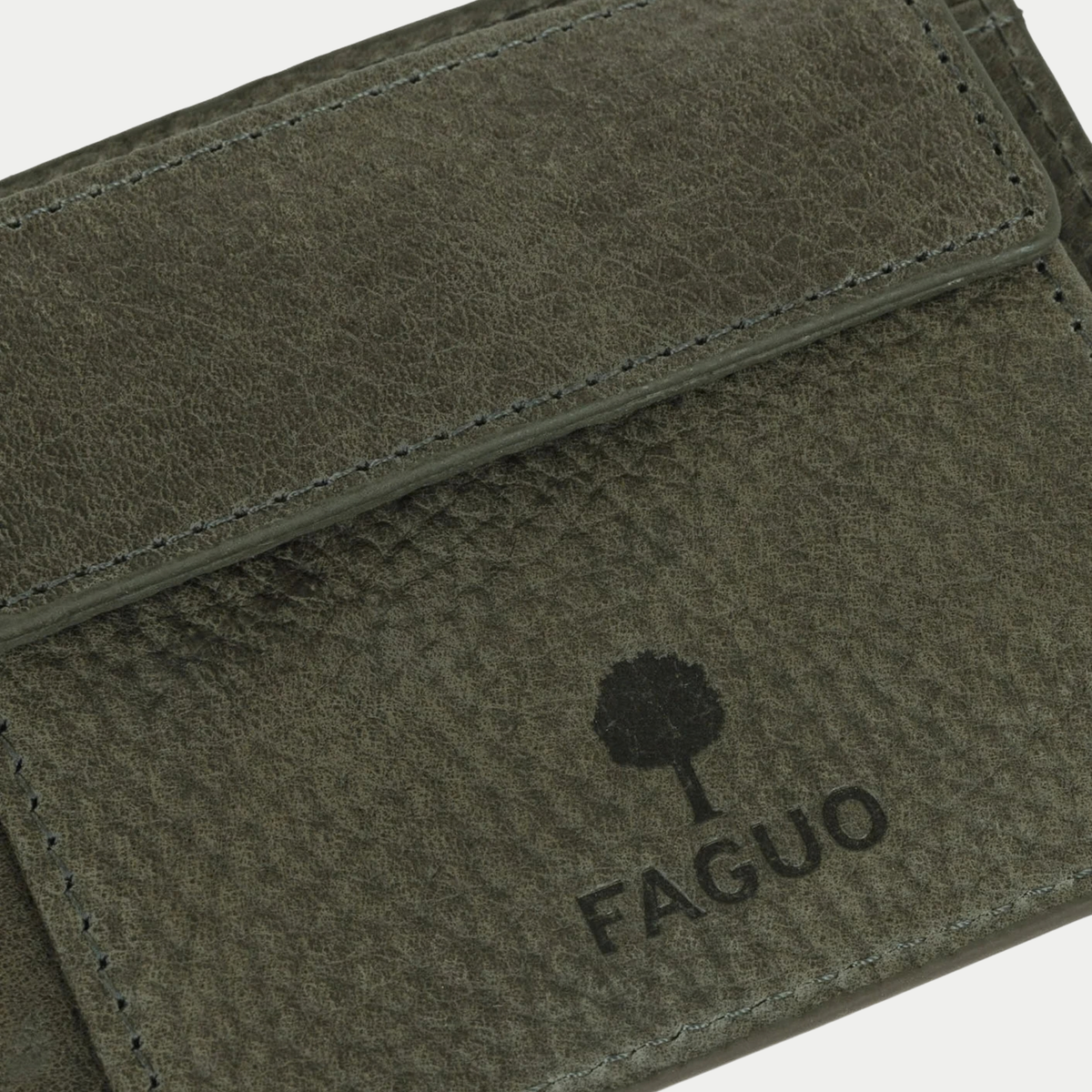 Détail du portefeuille Faguo vert foncé : rabat de la poche à monnaie et logo arbre embossé sur le cuir grainé