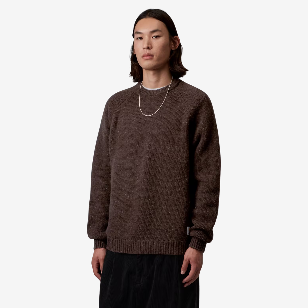 Pull Anglistic Tobacco Carhartt WIP porté de trois quarts : Square Label blanc cousu en bas de côté droit