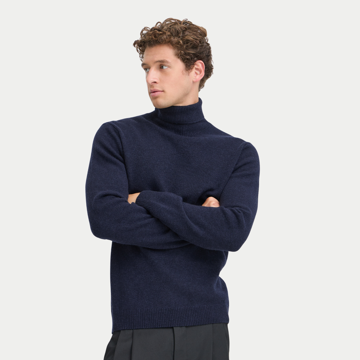 Pull col roulé bleu marine Navy Blazer Casual Friday porté de face, bras croisés, sur un pantalon noir