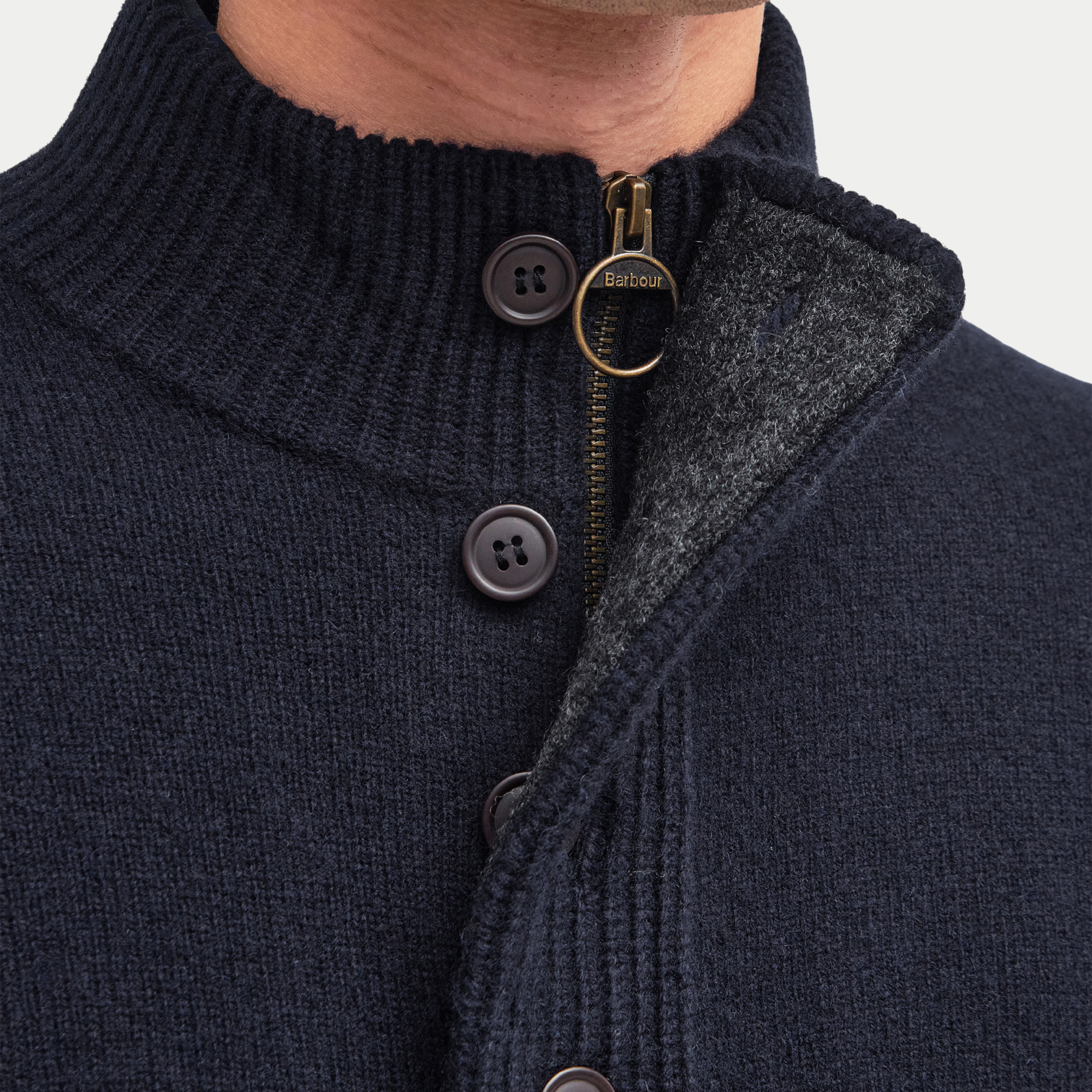 Macro du col du Pull Barbour Essential Patch : demi-zip laiton, boutons et doublure de col contrastante