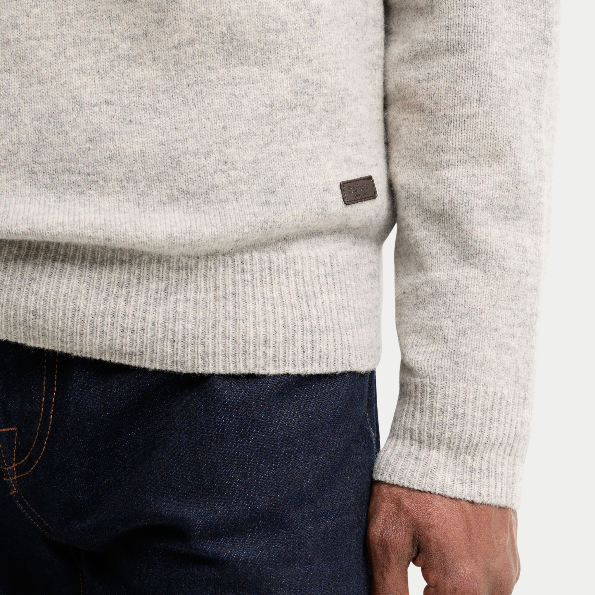 Détail du bas de pièce côtelé du Pull Barbour Essential Patch Light Grey Marl et de sa plaque Barbour