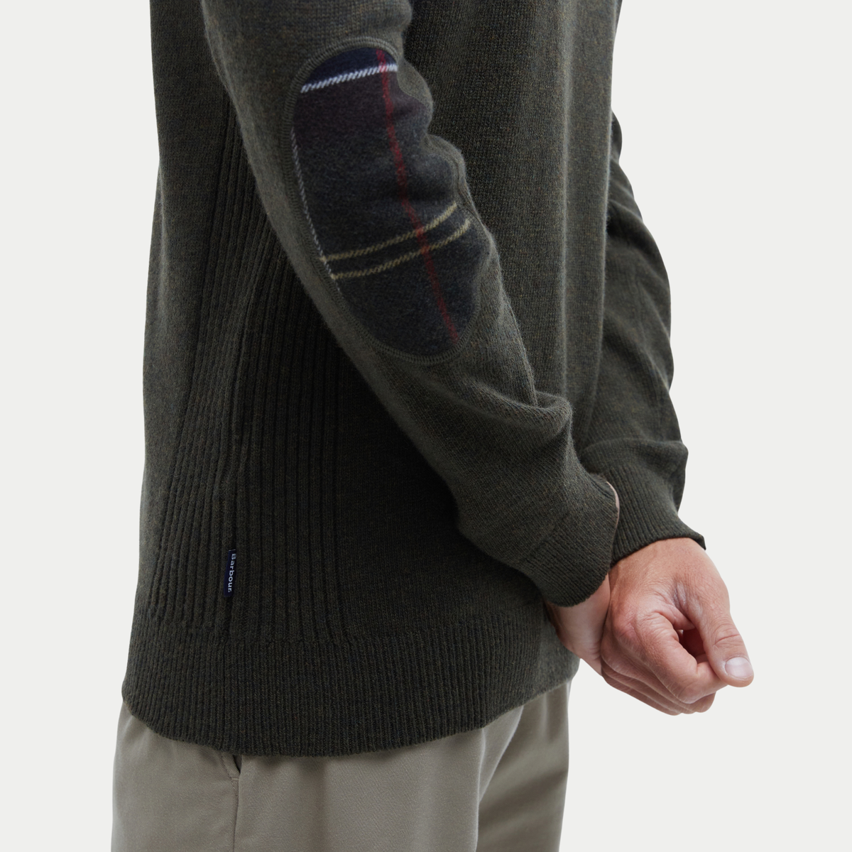 Détail d'un empiècement de coude en tartan Barbour sur le Pull Holden Olive Marl