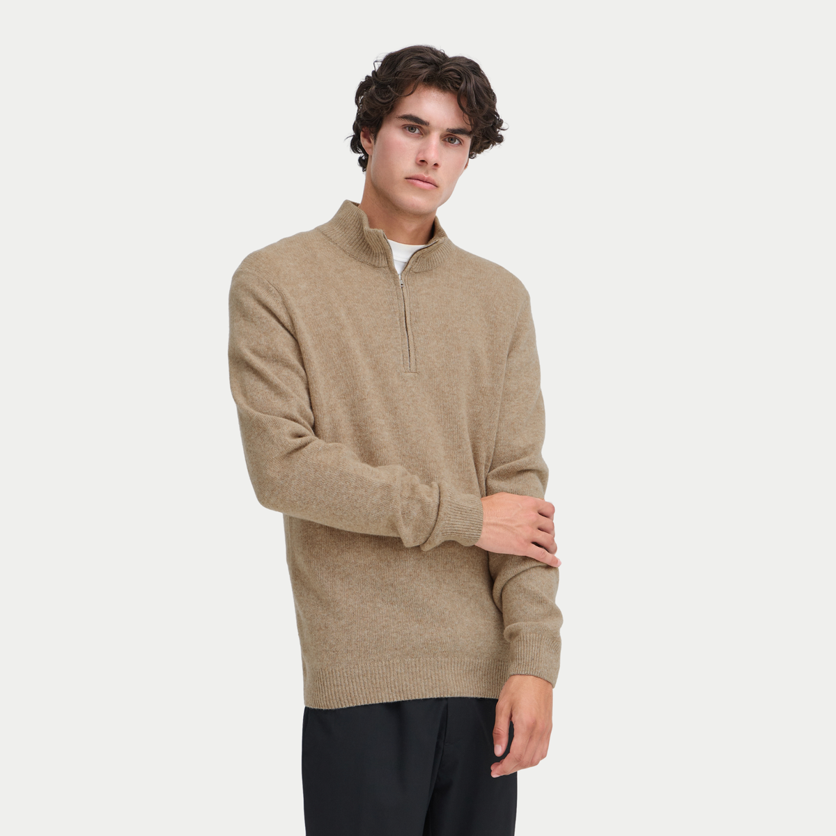 Pull half zip beige sable chiné porté de face, manche relevée sur le poignet côtelé