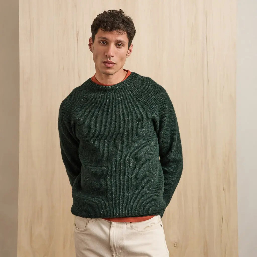 Pull Frehel en laine chinée vert foncé porté de face sur un pantalon écru