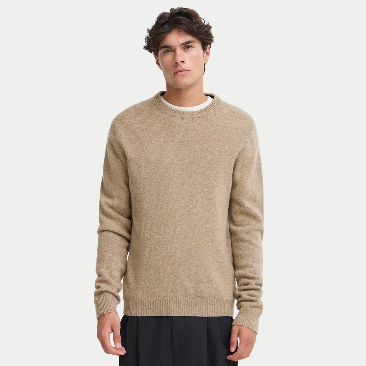 Pull en laine d'agneau marron clair chiné porté de face sur un t-shirt blanc, col rond côtelé