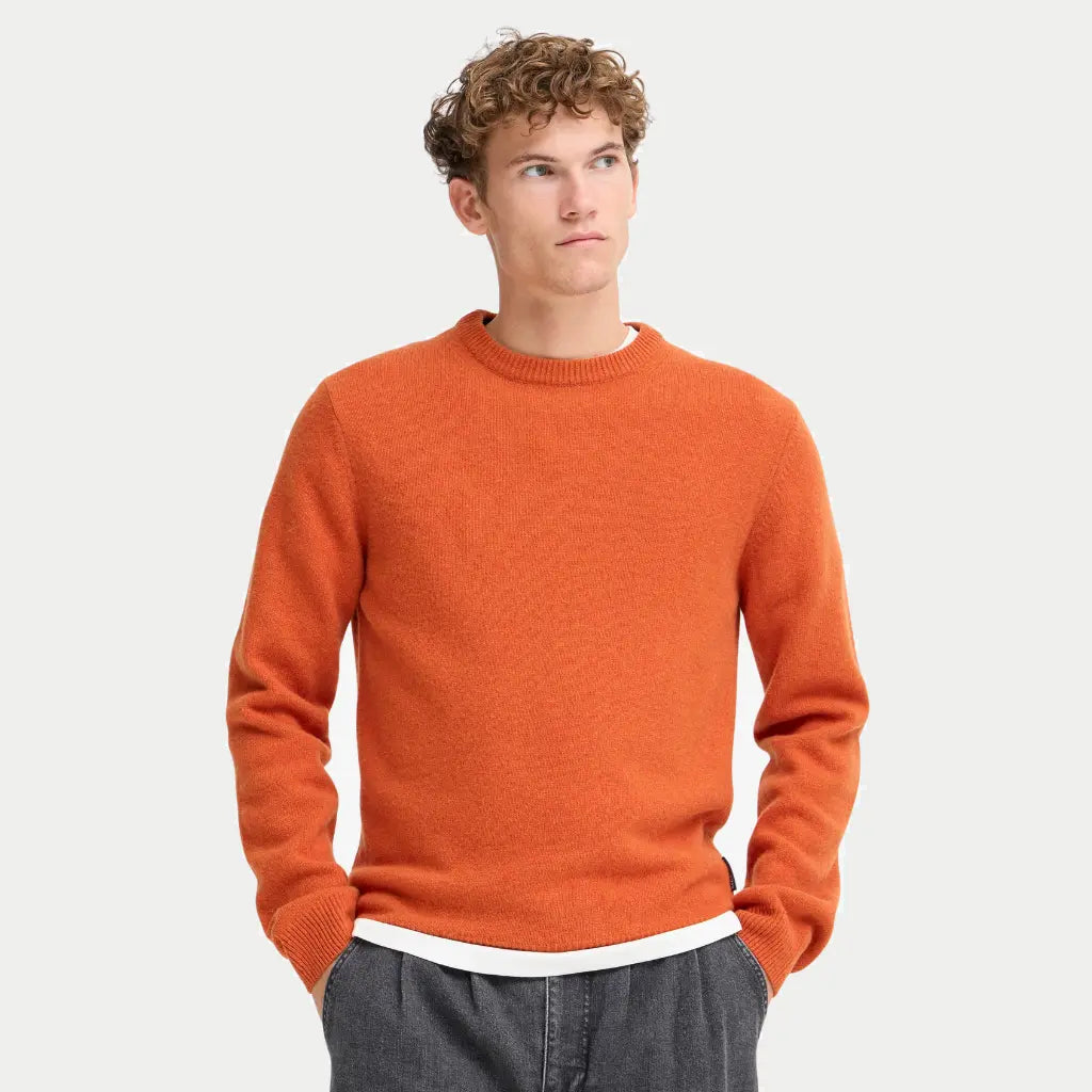 Pull Burnt Ochre porté, col rond côtelé et bord-côte de taille laissant dépasser un t-shirt blanc