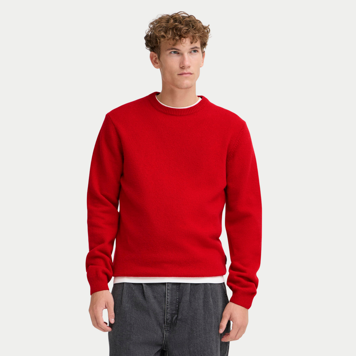 Pull Casual Friday rouge porté de face, maille fine unie avec un jean gris