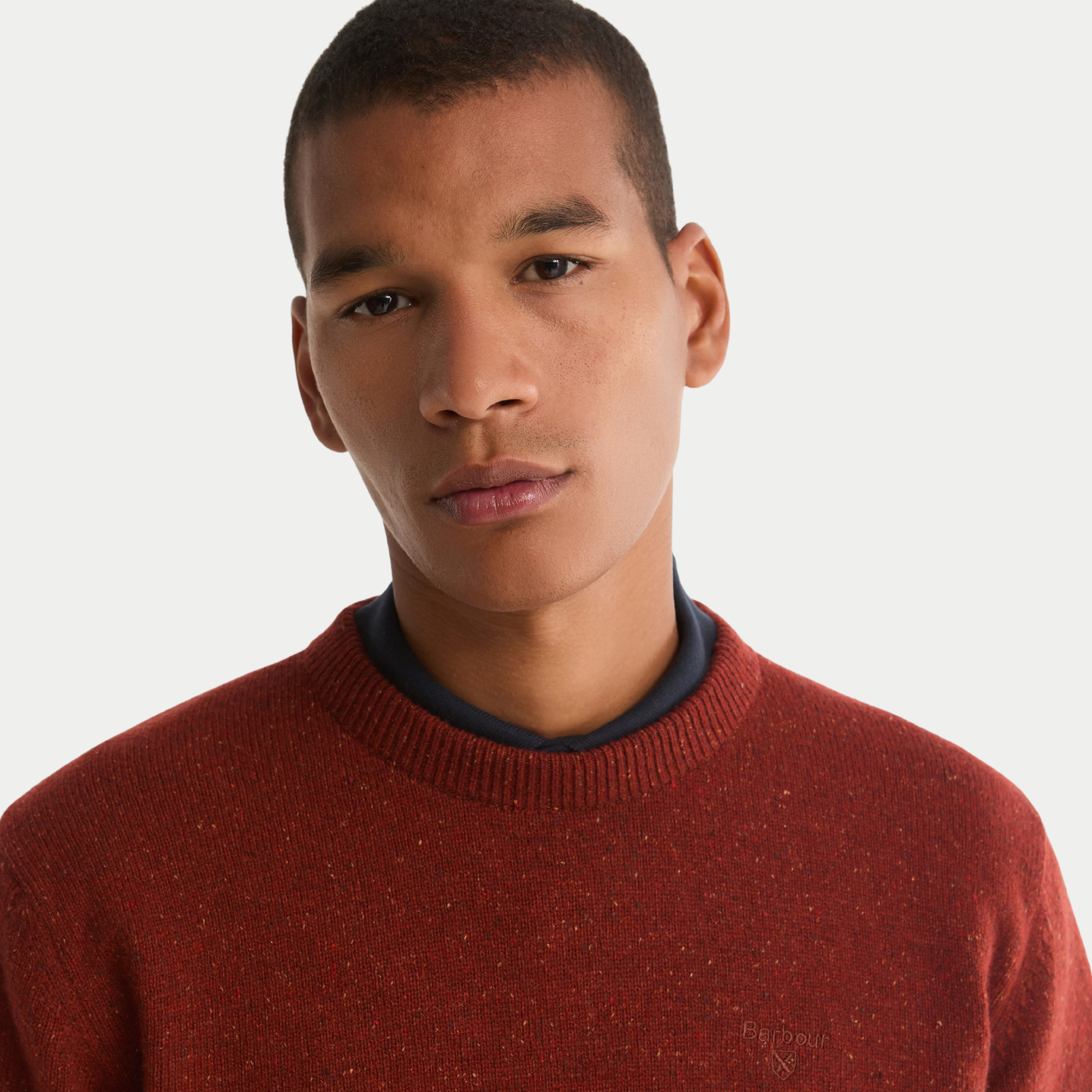 Gros plan de l'encolure côtelée du Pull Barbour Tisbury Russet et des nepps du fil tweed