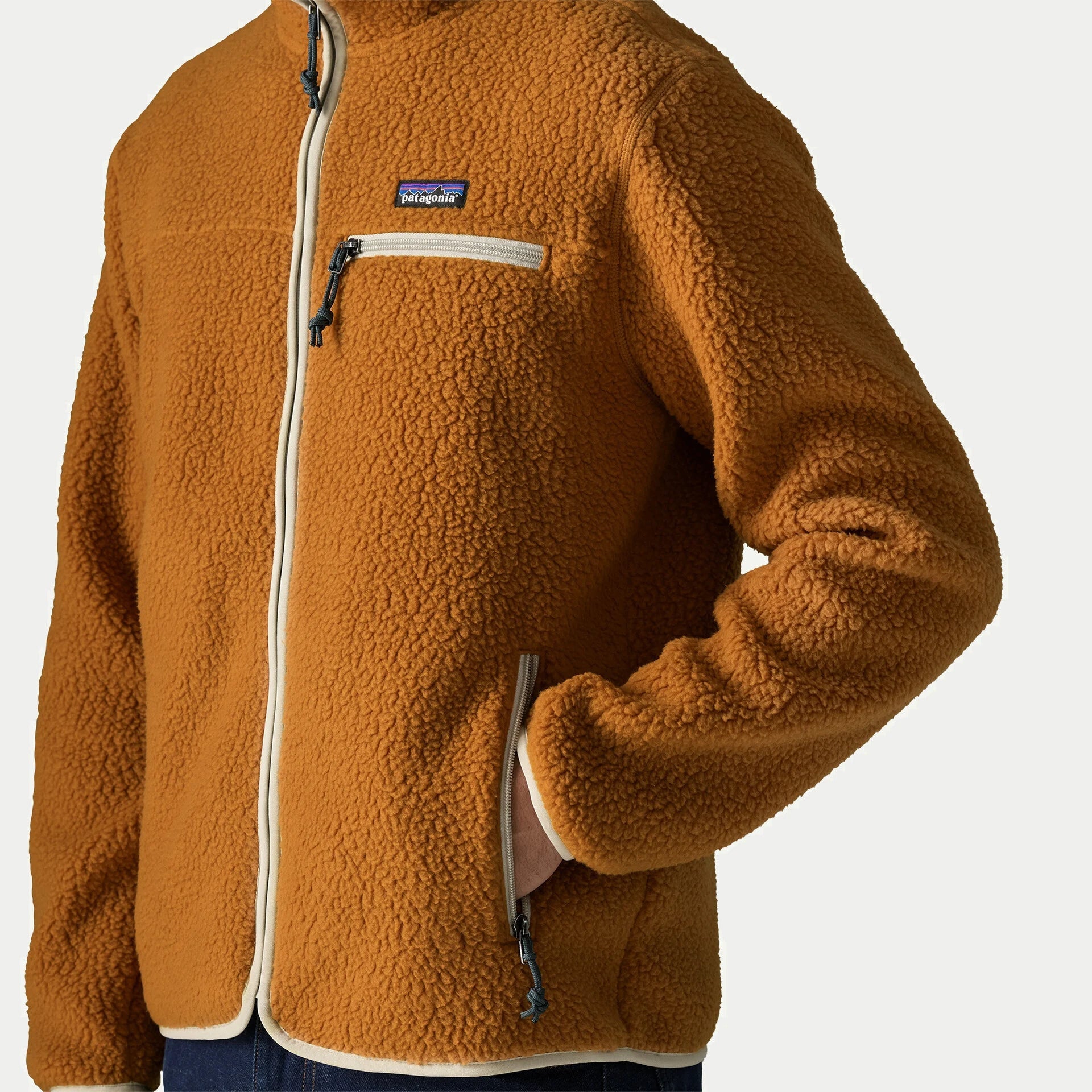 Détail poitrine de la veste Retro Pile Cinnamon Brown Patagonia : poche zippée à ruban crème et étiquette de marque