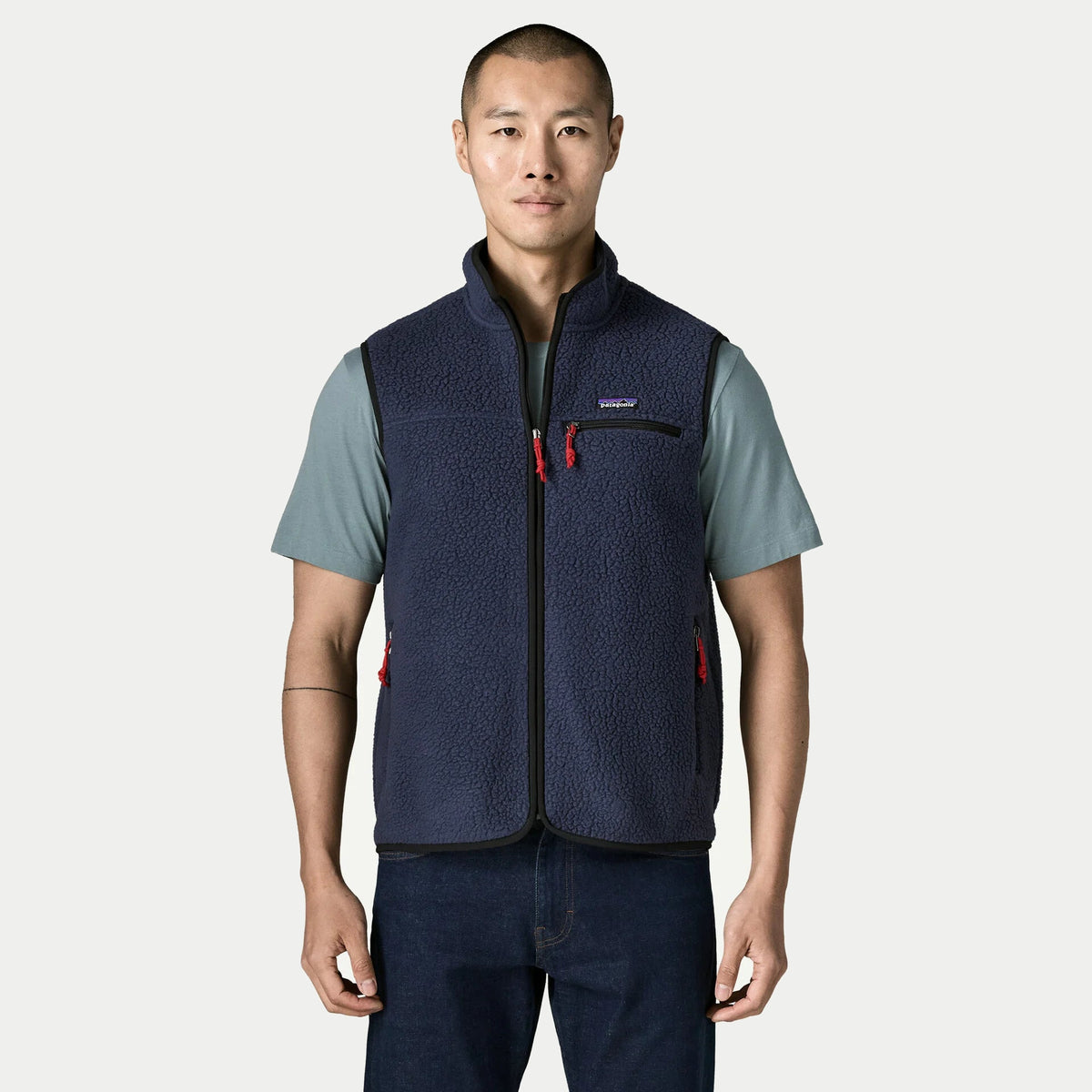 Gilet Retro Pile New Navy Patagonia porté de face, col montant zippé, poche poitrine et deux poches basses zippées